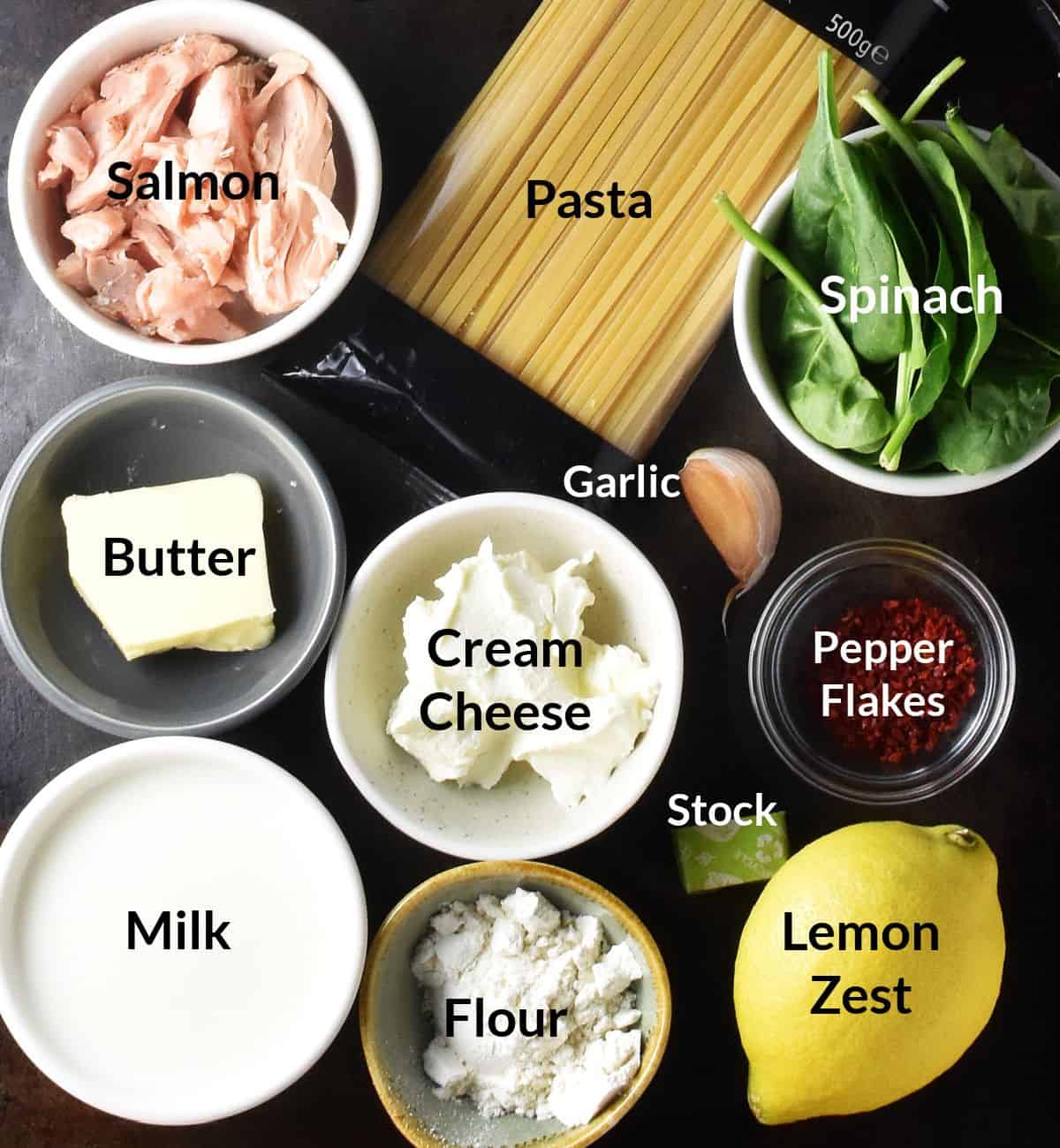 Ingredients for making salmon and spinach pasta in individual dishes.