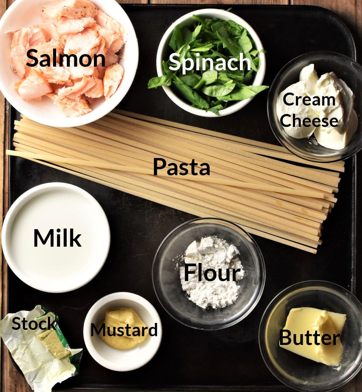 Ingredients for making healthy salmon pasta with spinach in individual dishes.