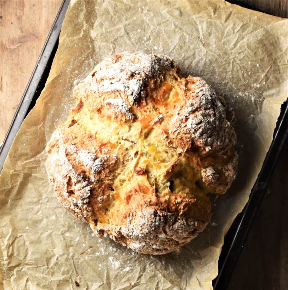 Baked sun dried tomato loaf on top of parchment.