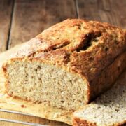 Close-up side view of banana bread with quinoa on top of parchment.