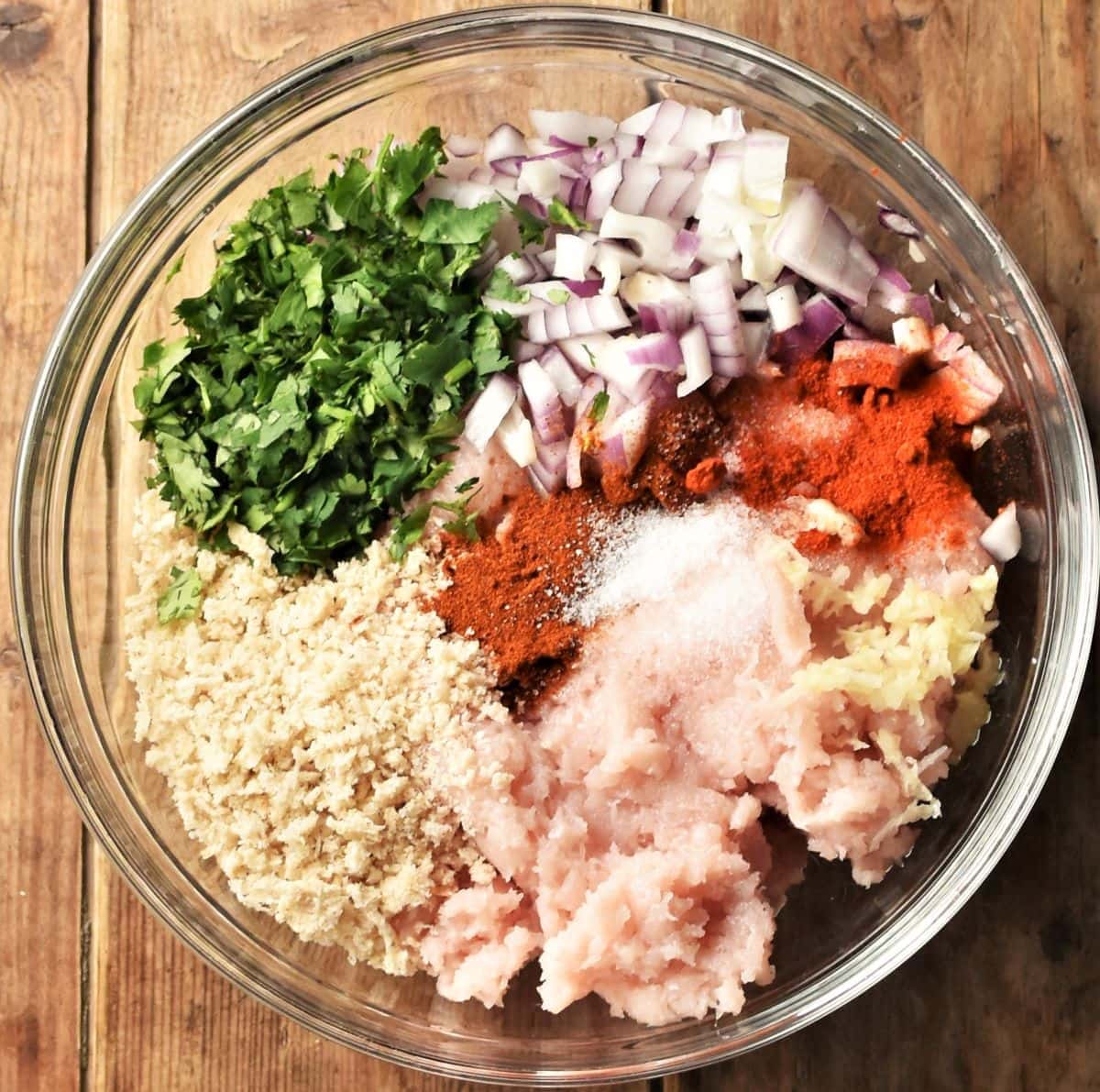 Spicy chicken burgers ingredients in mixing bowl.
