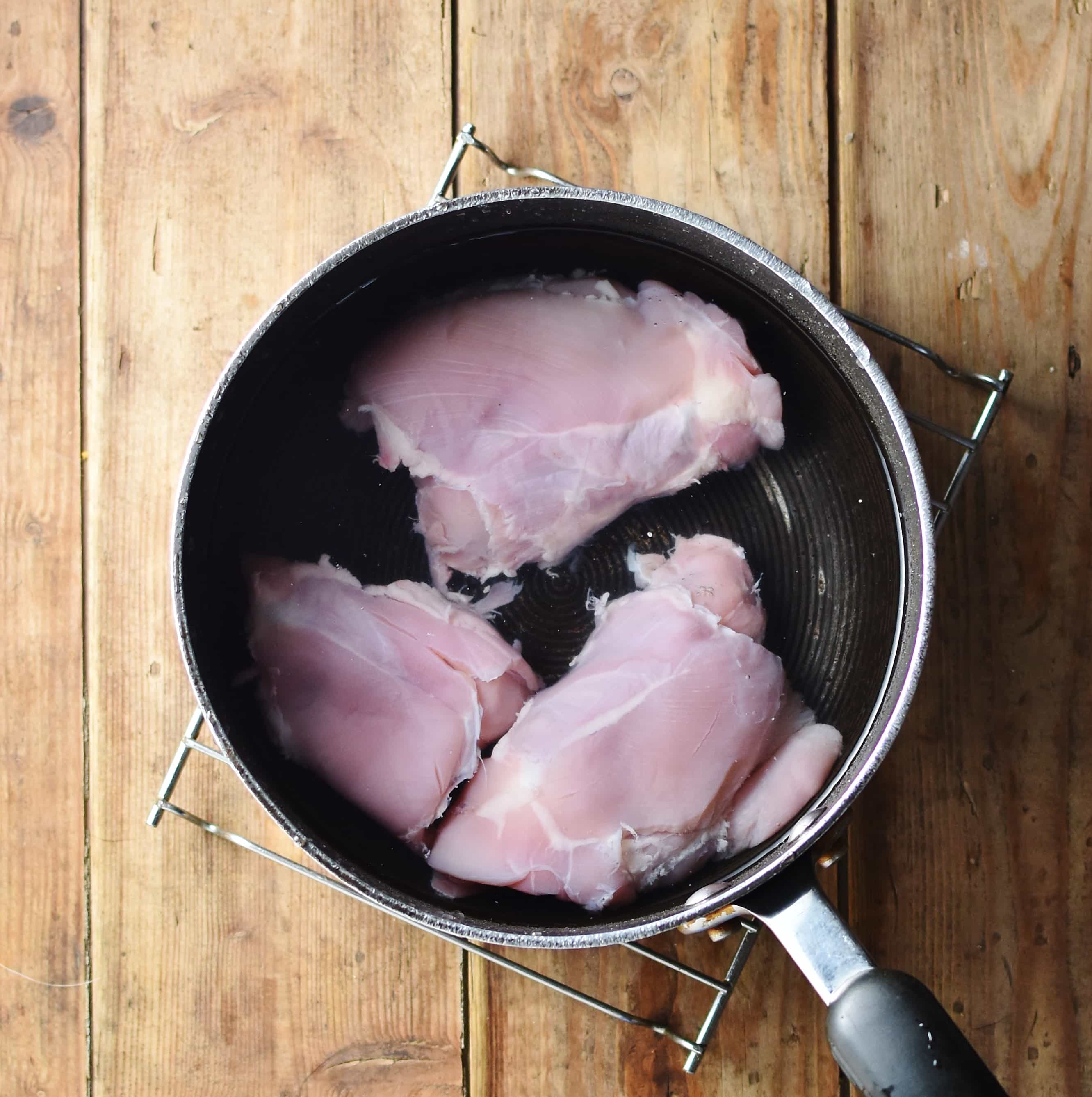 3 skinless chicken thighs in large pot with water.