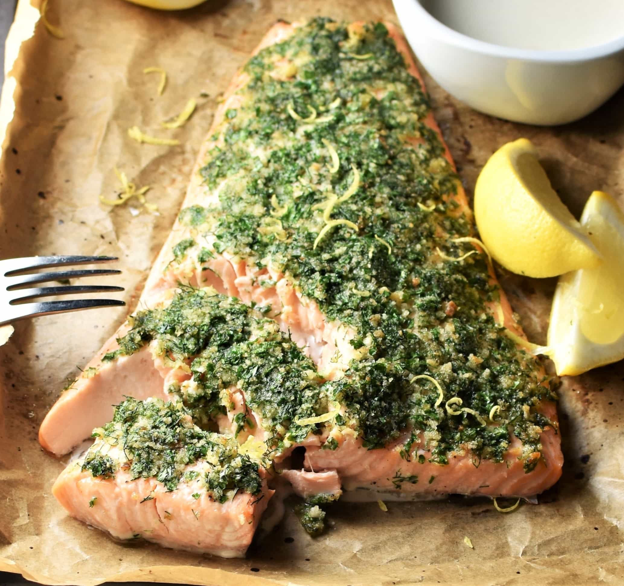 Close-up with of herb salmon with lemon wedges.