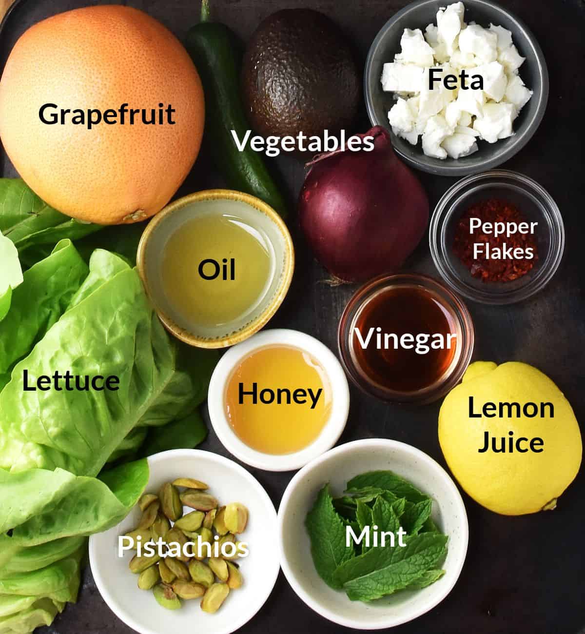 Top down view of grapefruit salad ingredients in individual dishes clustered together.