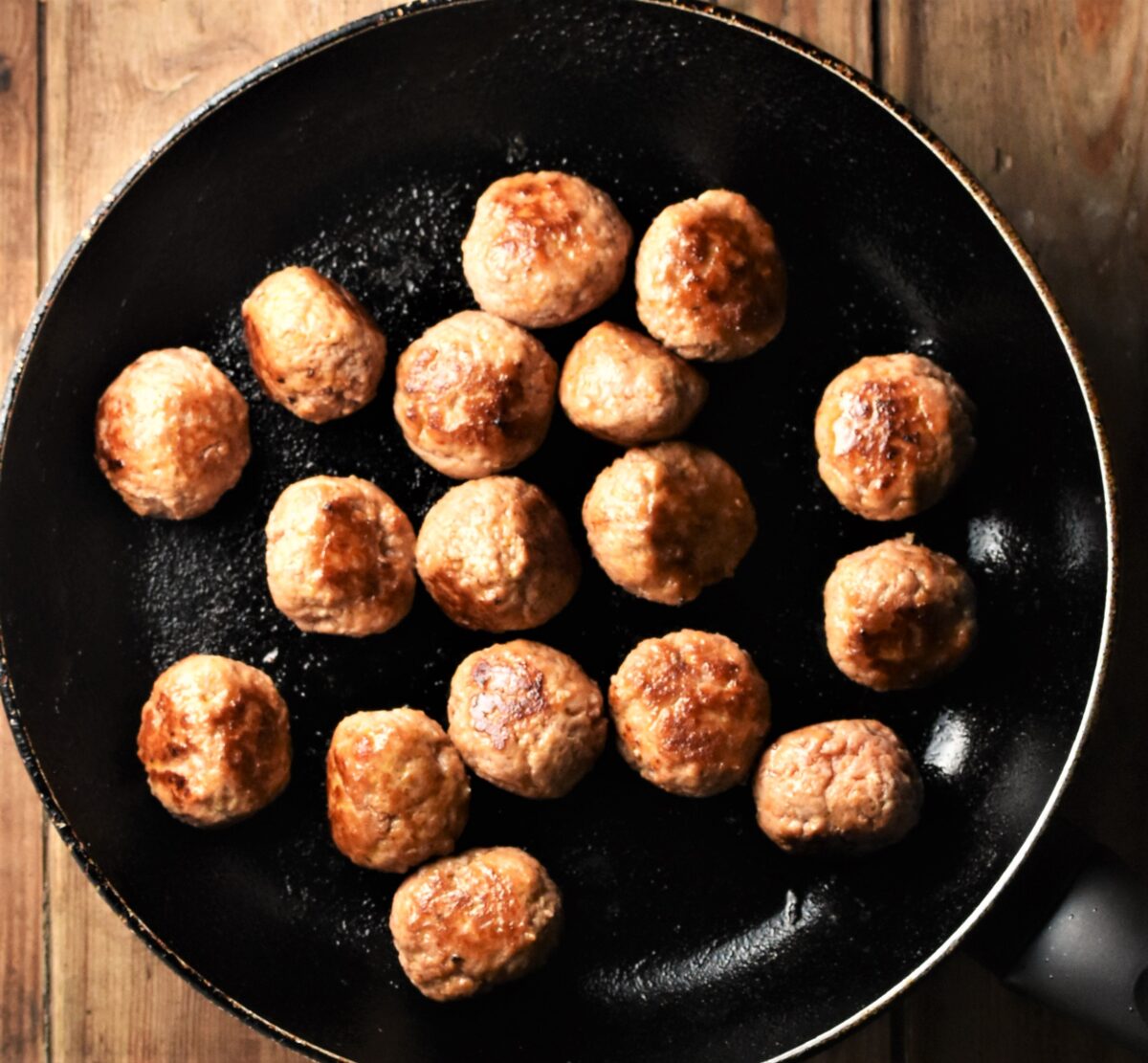 Fried meatballs in large pan.