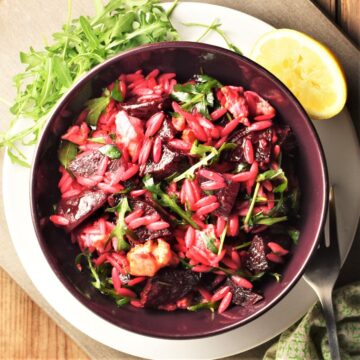 Top down view of beetroot and feta salad in purple bowl.