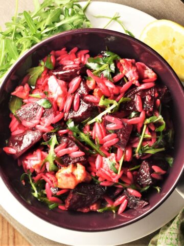 Top down view of beet and feta salad in purple bowl.