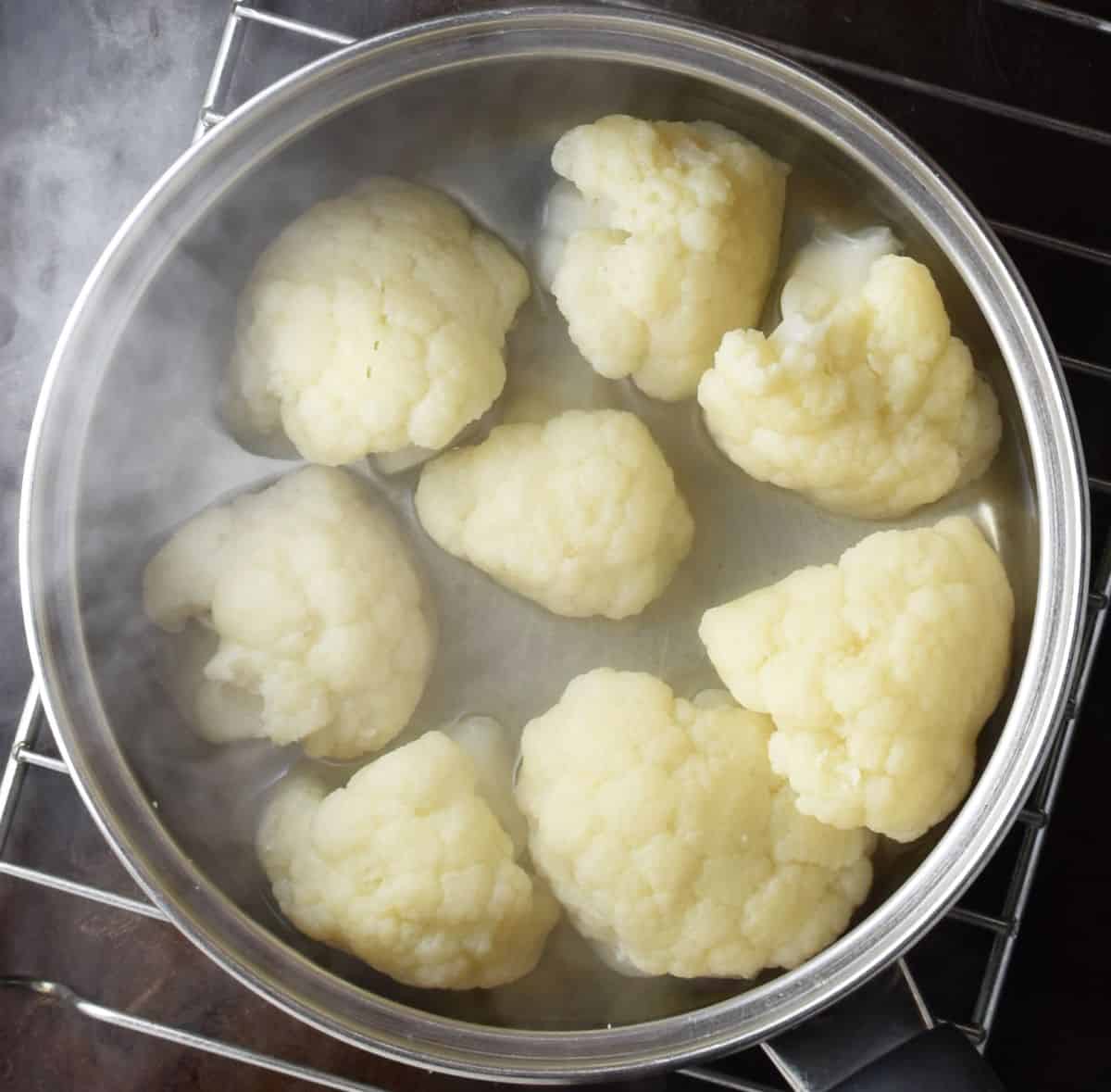 Cauliflower florets for patties with water in pot.