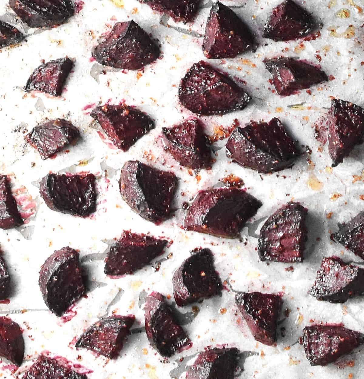 Top down view of roasted beet chunks spread over parchment.