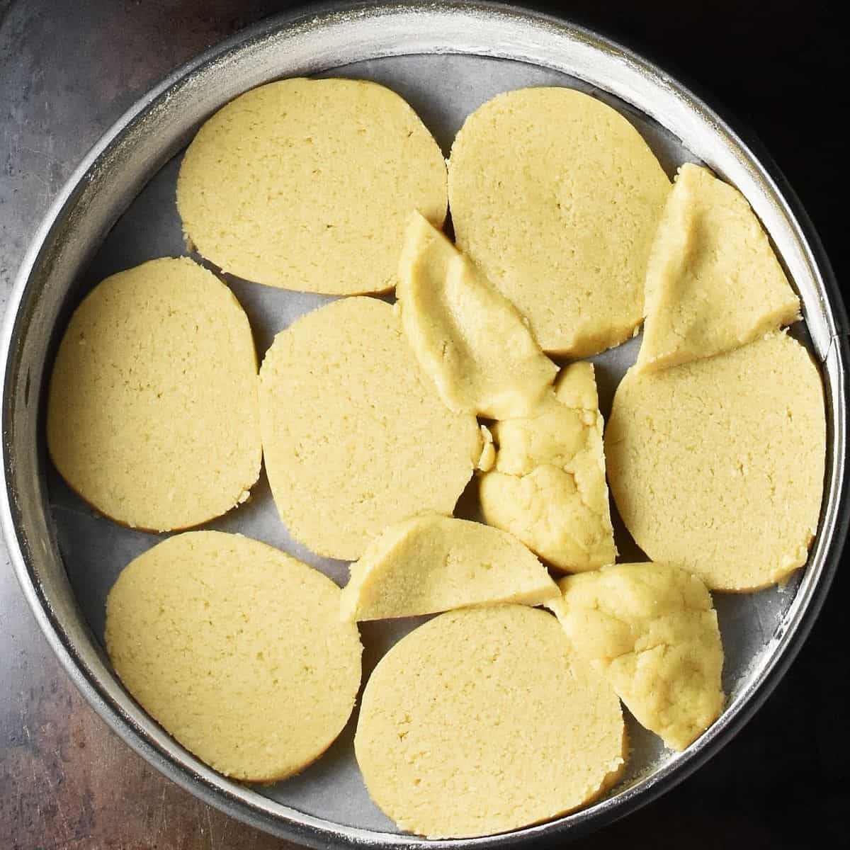 Slices of pastry covering bottom of round cake pan.