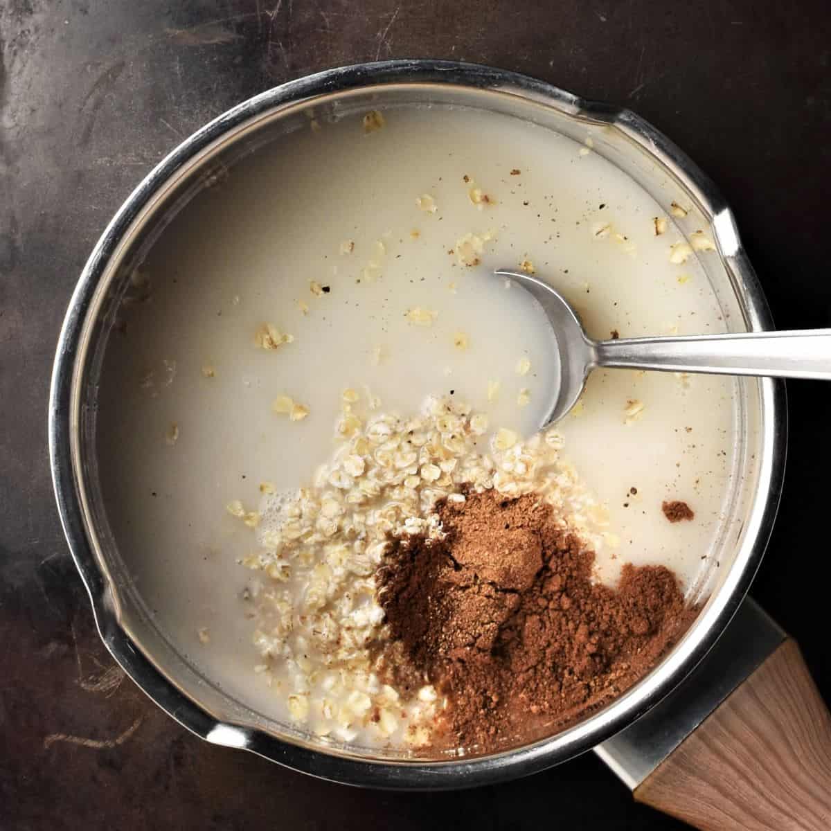 Combining chai porridge ingredients in saucepan with spoon.
