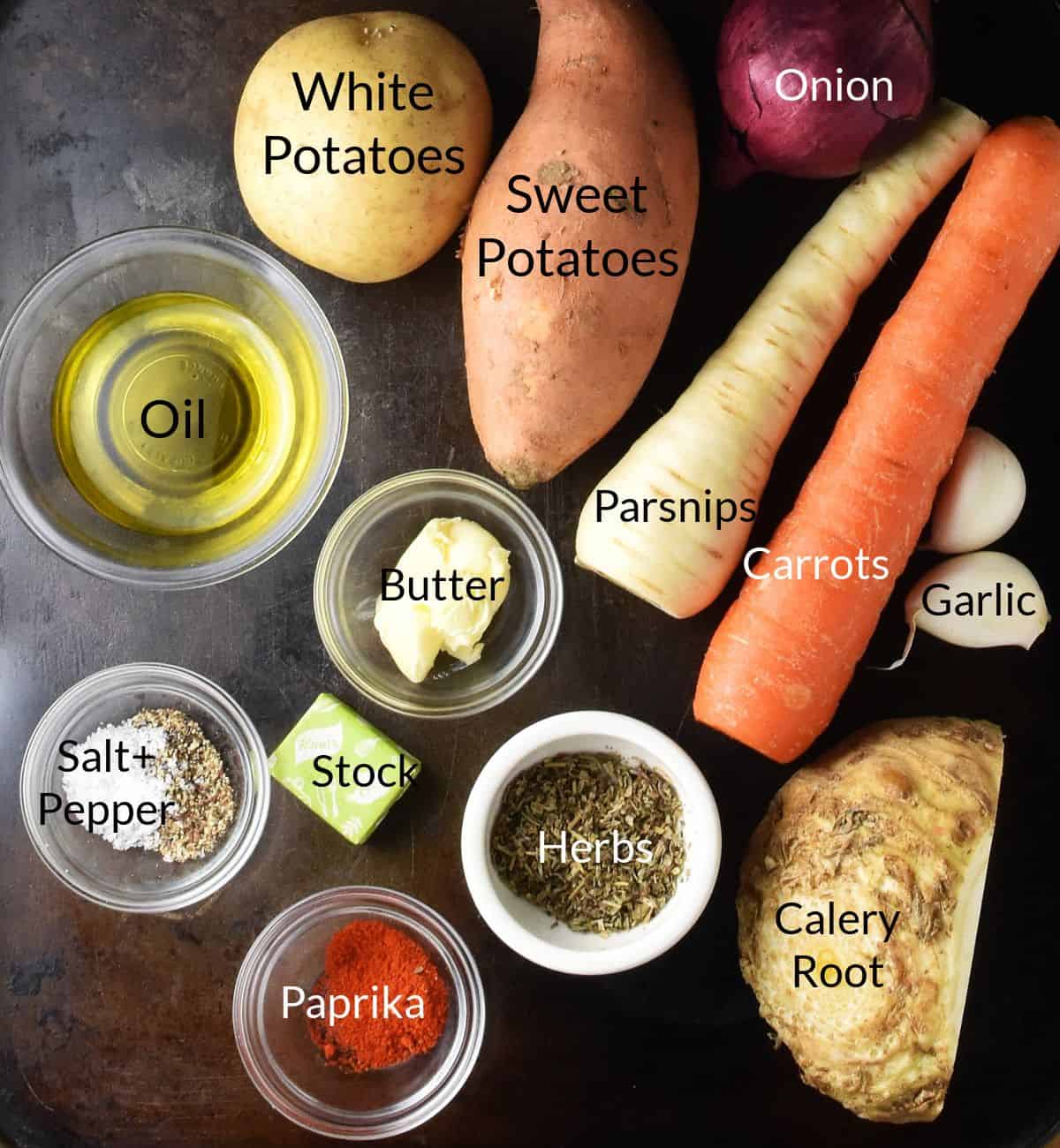 Top down view of ingredients for making roasted root vegetable soup on metal surface.