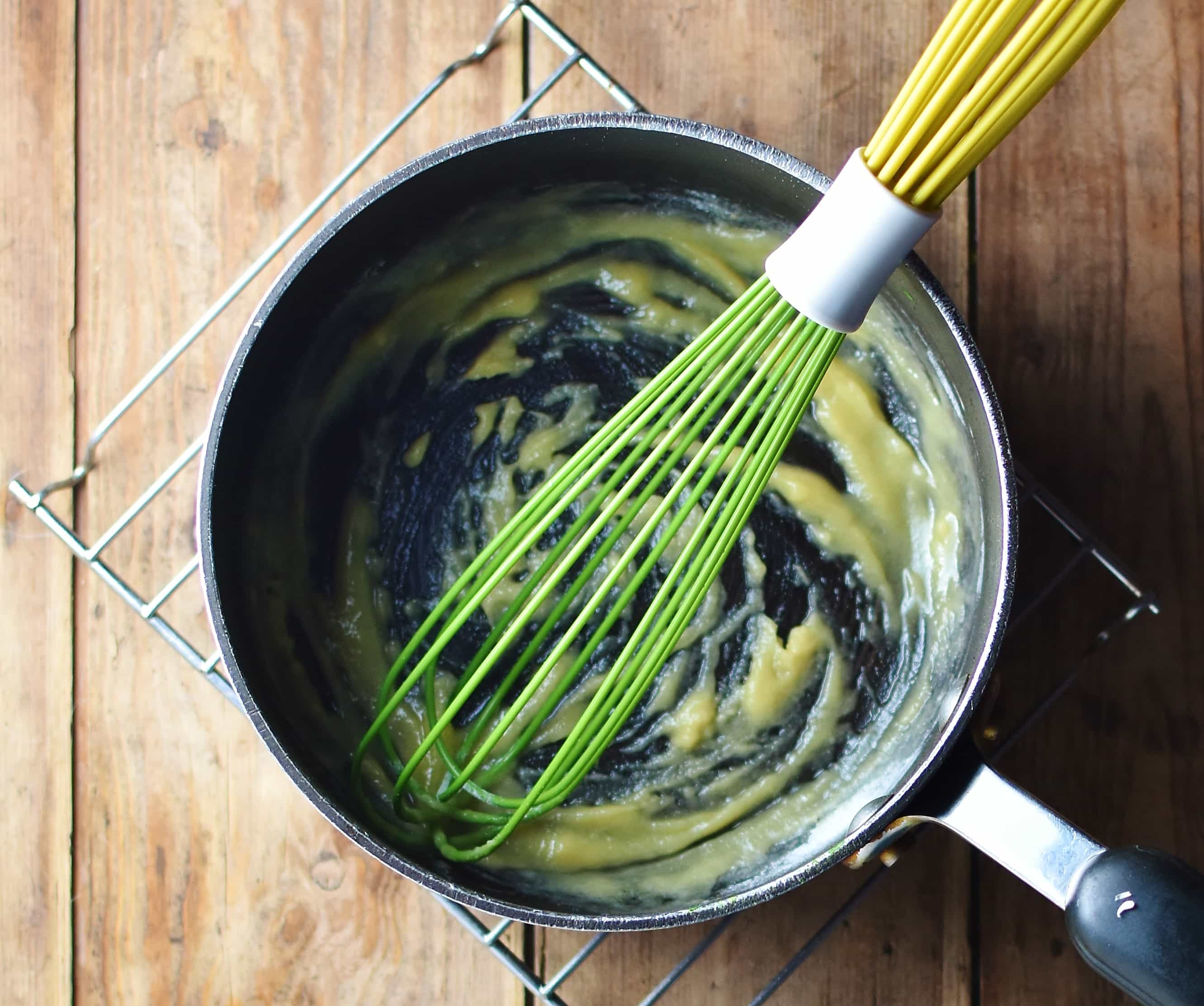 Roux in large pot with green whisk.
