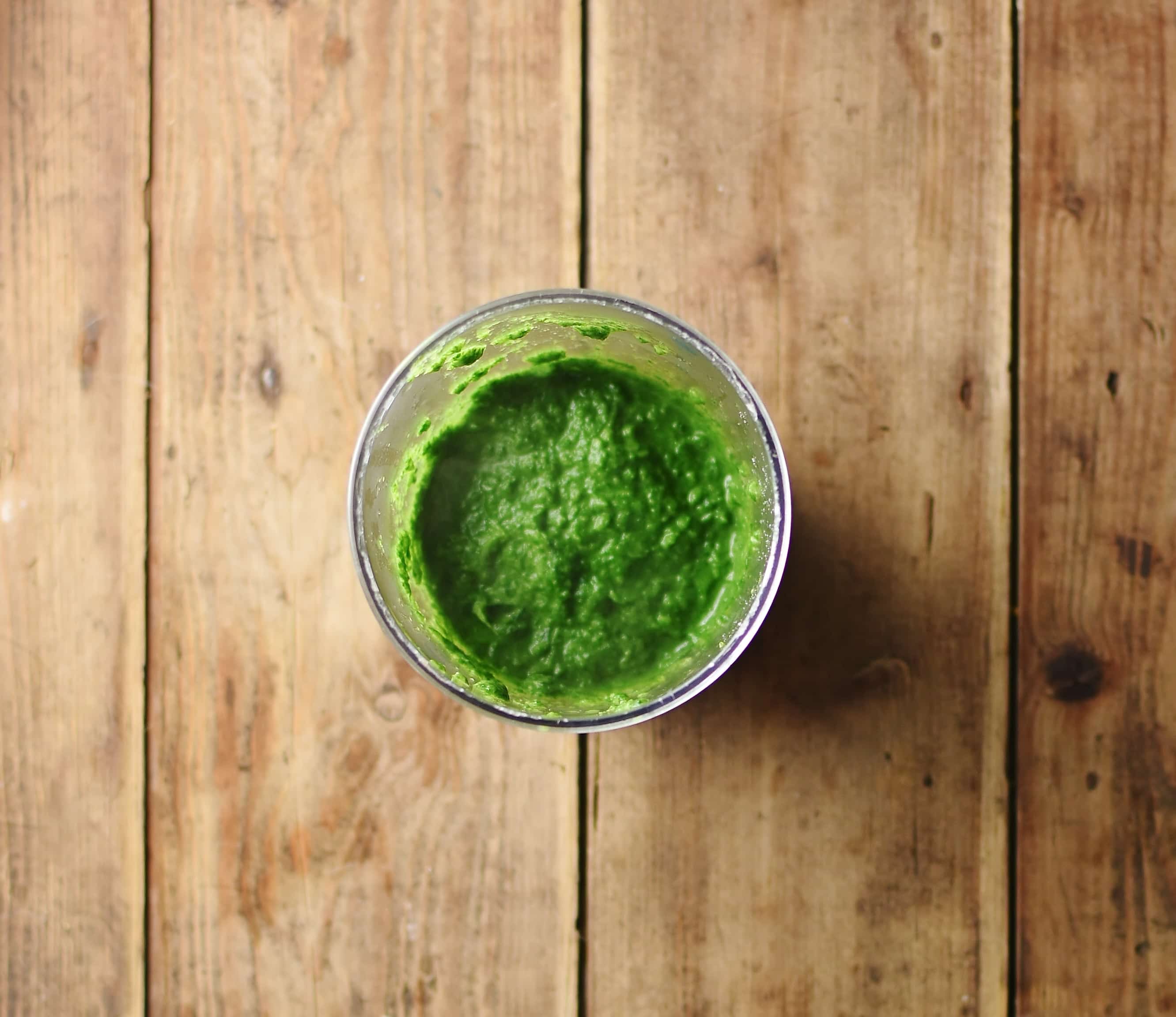 Top down view of spinach puree inside small dish.