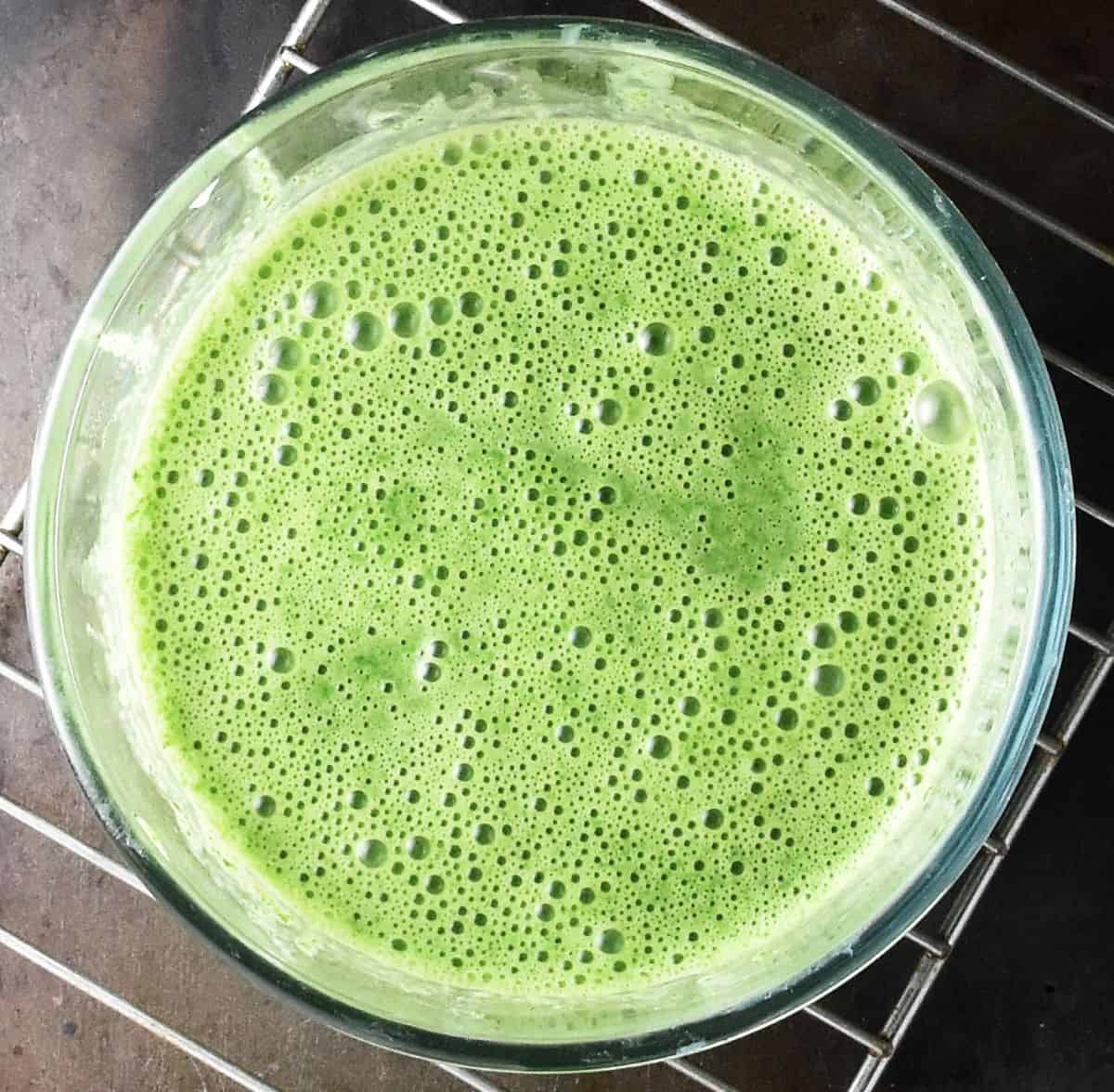 Pureed spinach sauce mixture in glass bowl.