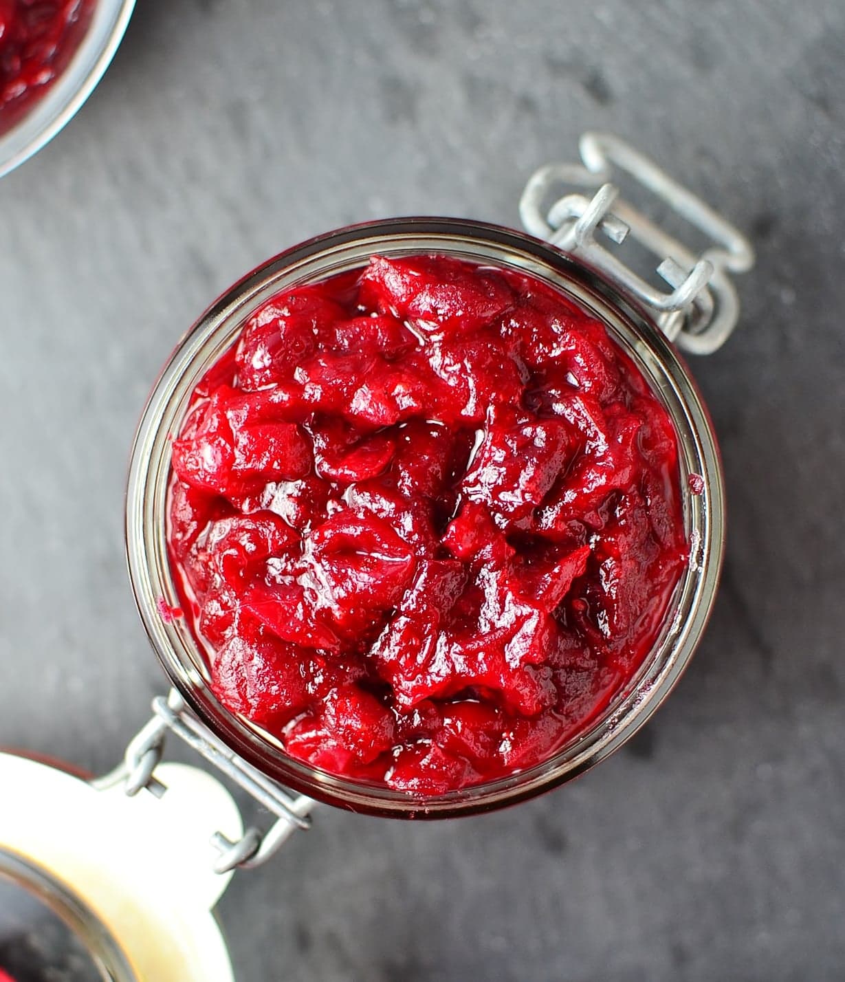 Top down view of chunky cranberry sauce in open jar.