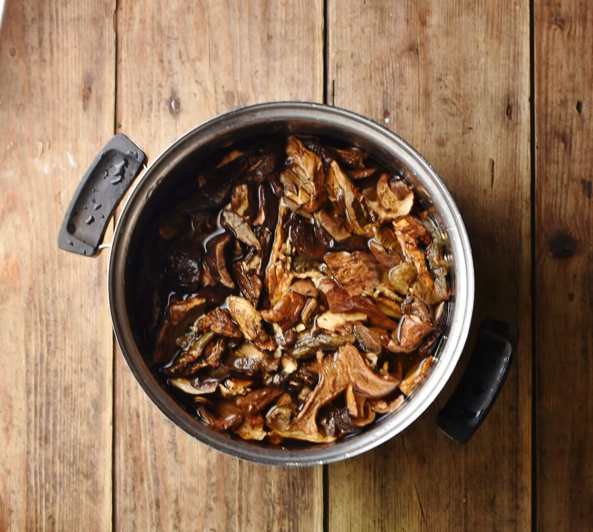 Dried porcini mushrooms in pot with water.