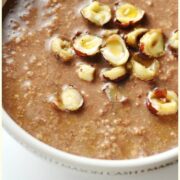 Partial view of mocha overnight oats with chopped hazelnuts in white bowl.