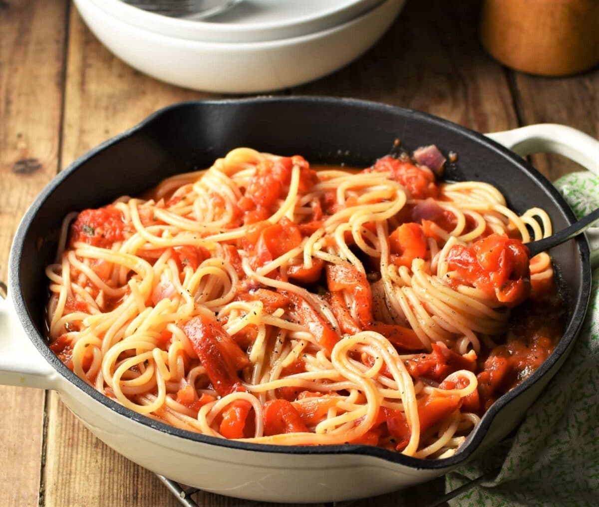 Side view of red pepper spaghetti in pan with fork.