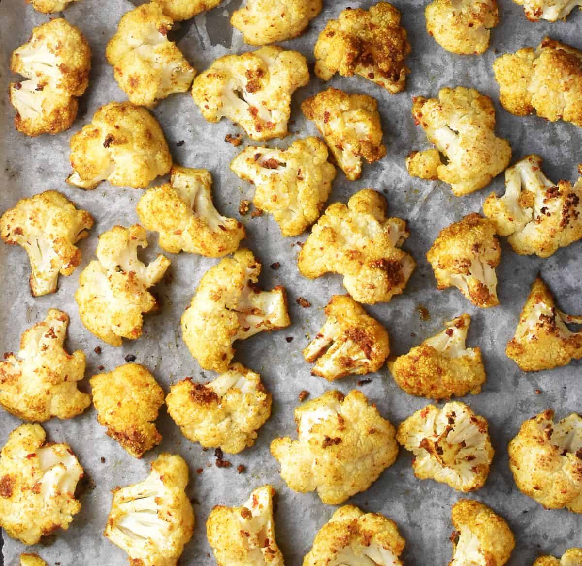 Roasted cauliflower florets on parchment paper.