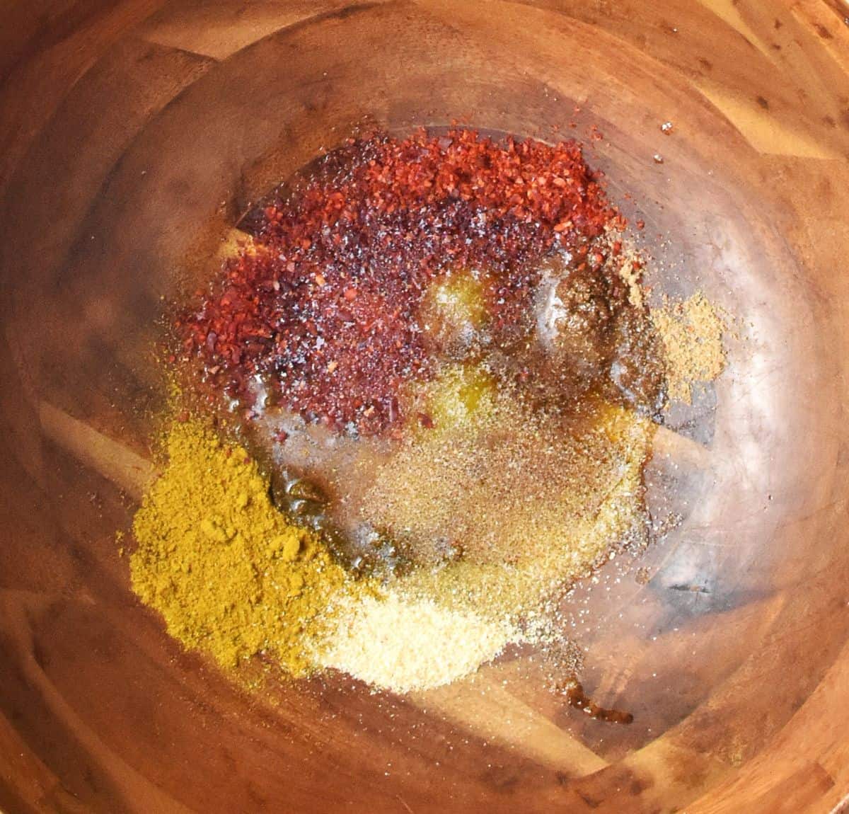Spices and oil in large wooden bowl.