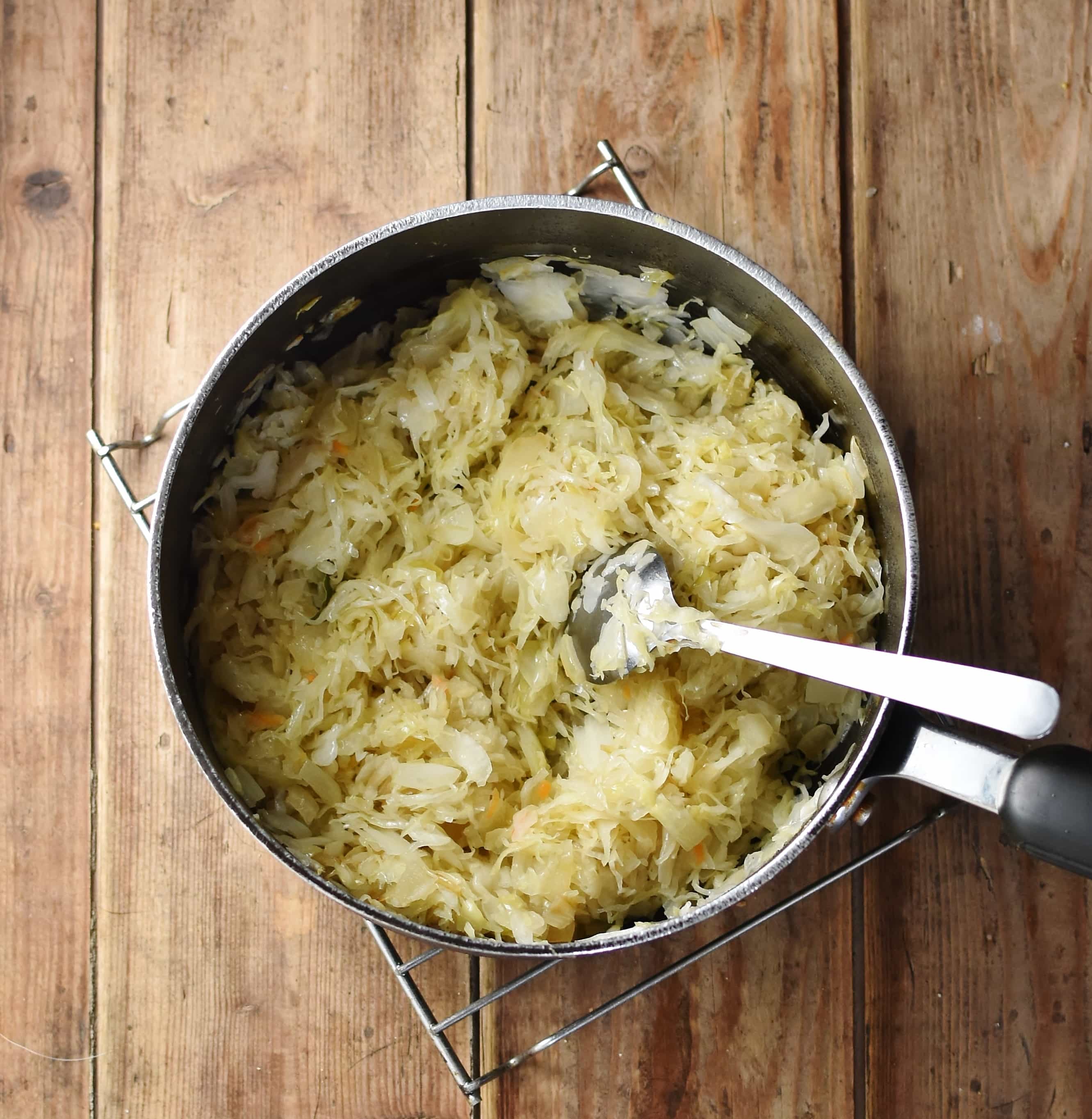 Sauerkraut in large pot with spoon.