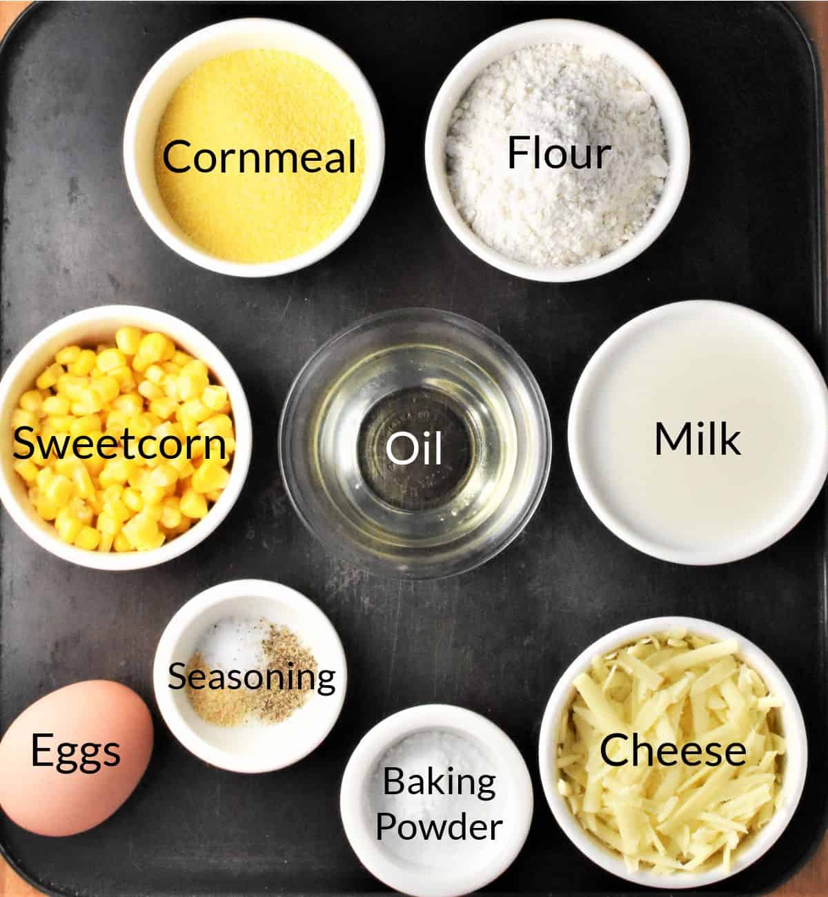 Ingredients for making cornmeal muffins with corn in individual dishes.