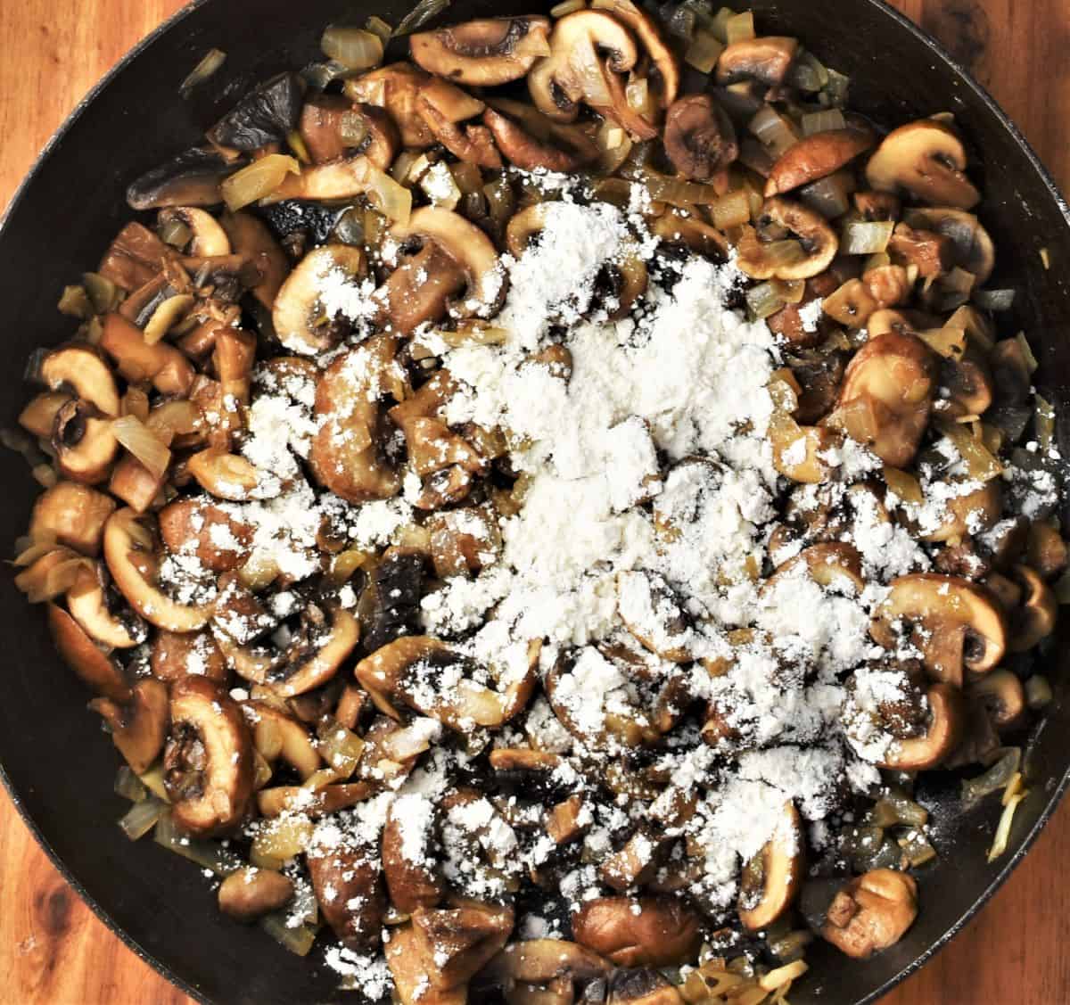 Fried mushrooms with flour in large pan.