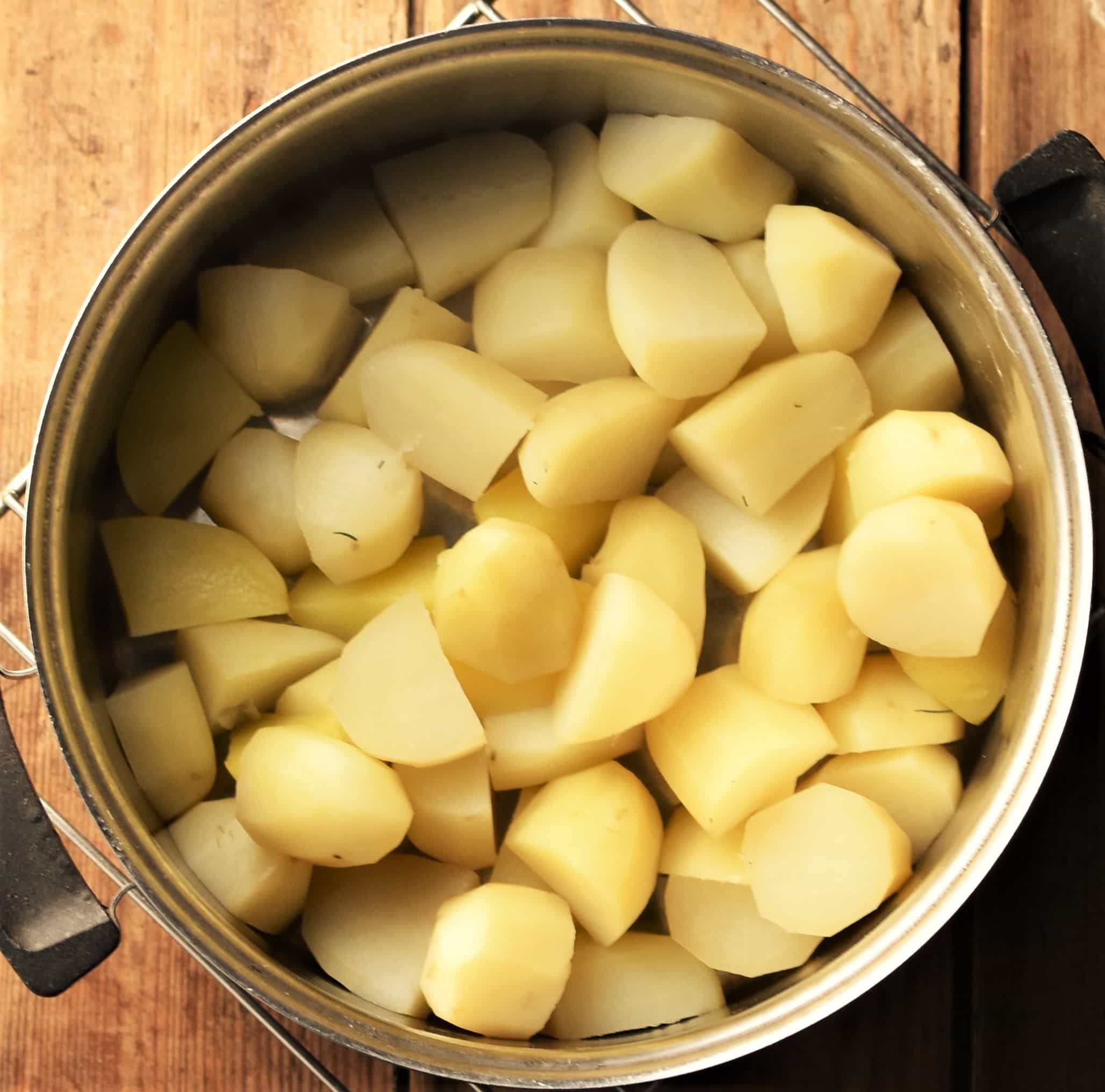 Cubed peeled potatoes in pot.