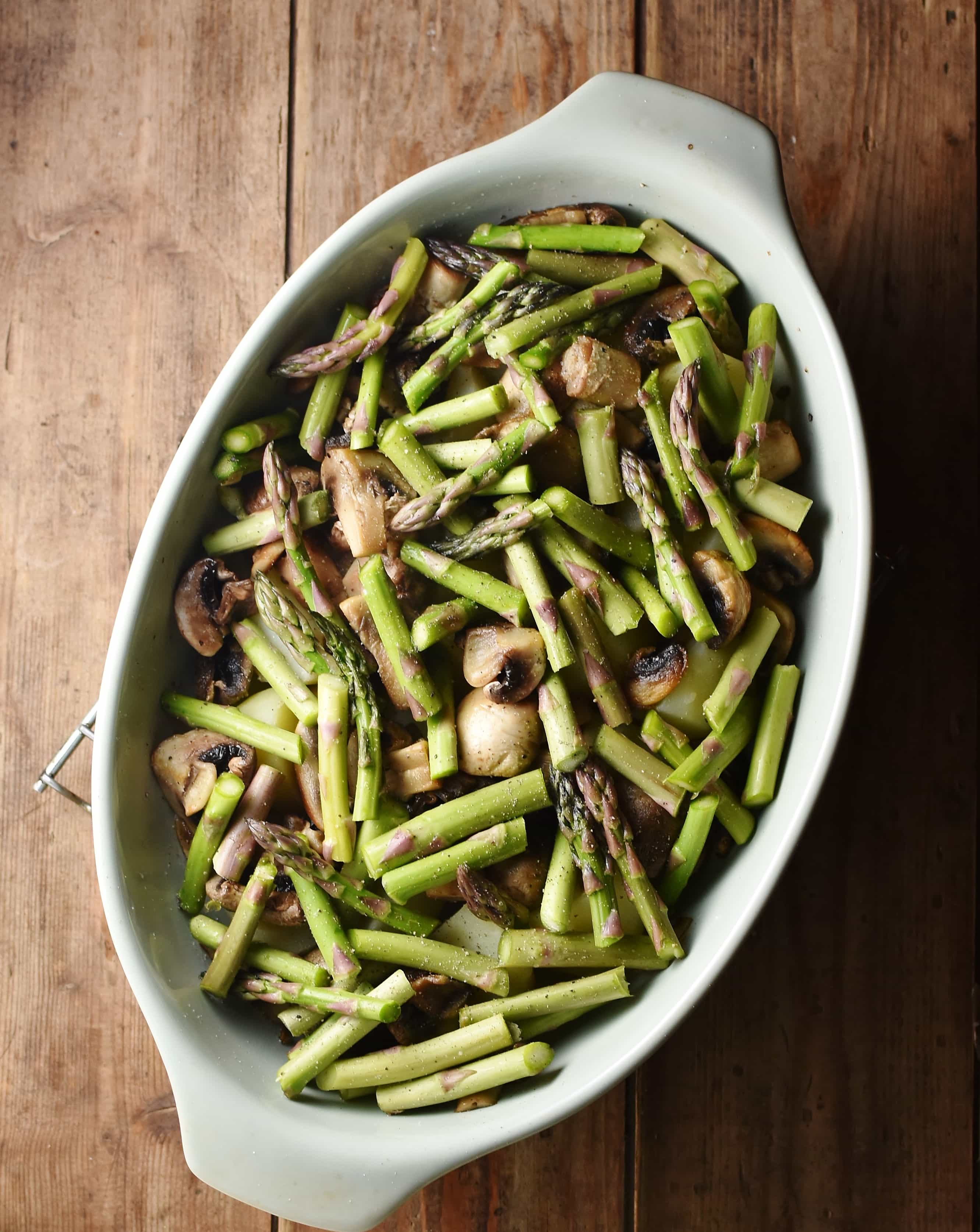 Chopped asparagus and mushrooms in oval dish.