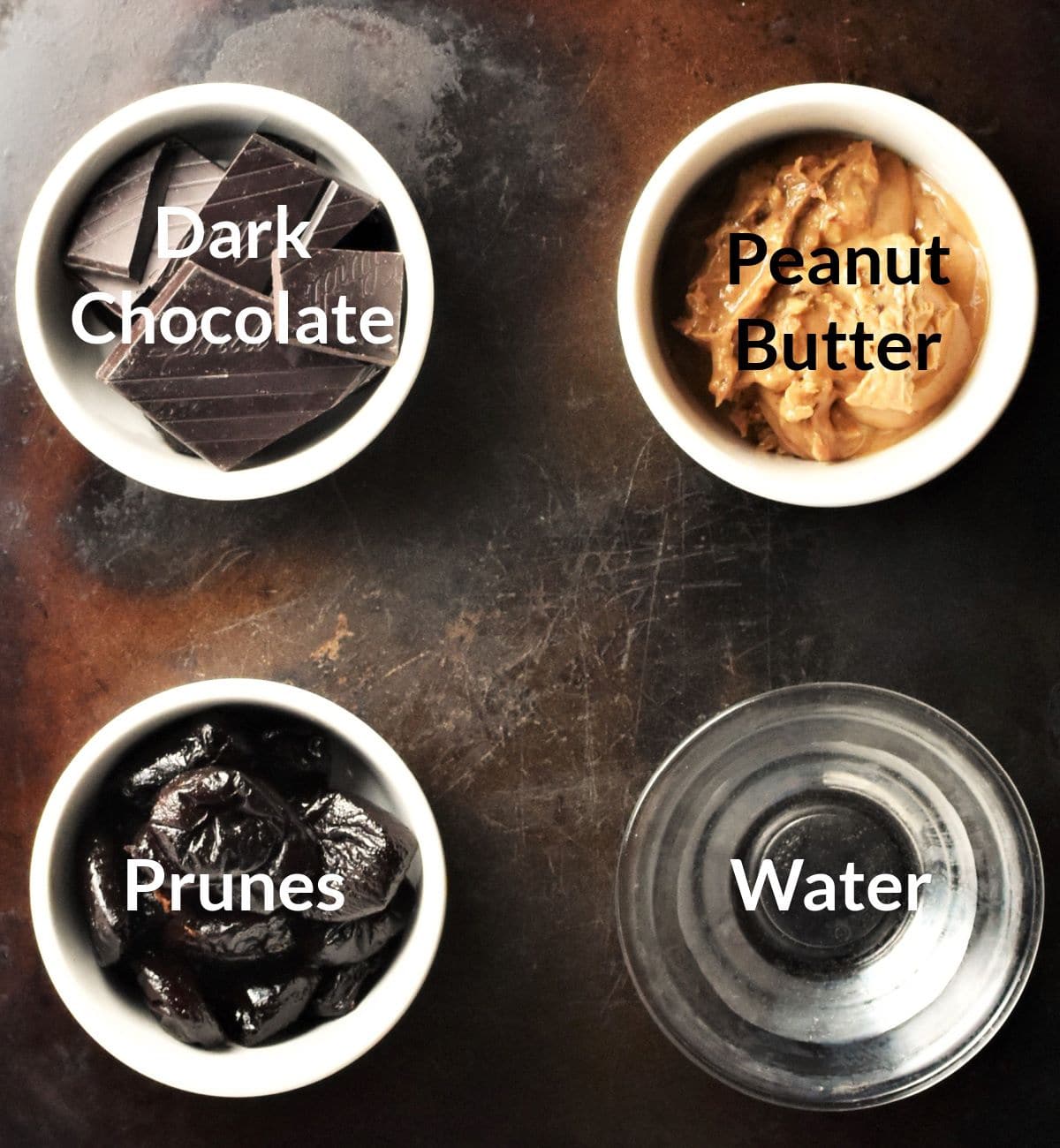 Ingredients for making chocolate prune energy balls in individual dishes.