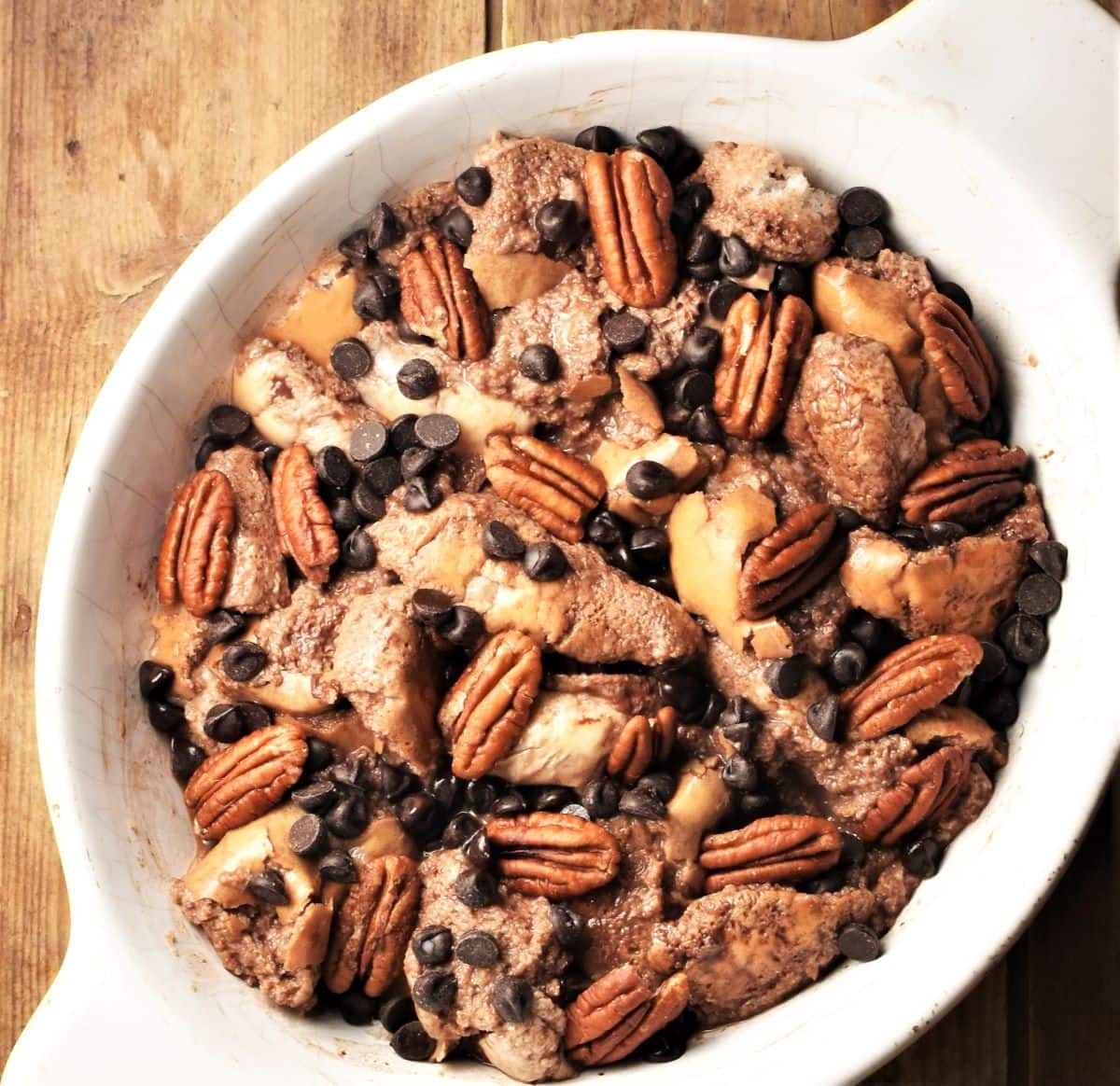 French toast casserole with chocolate chips and pecans in oval dish.