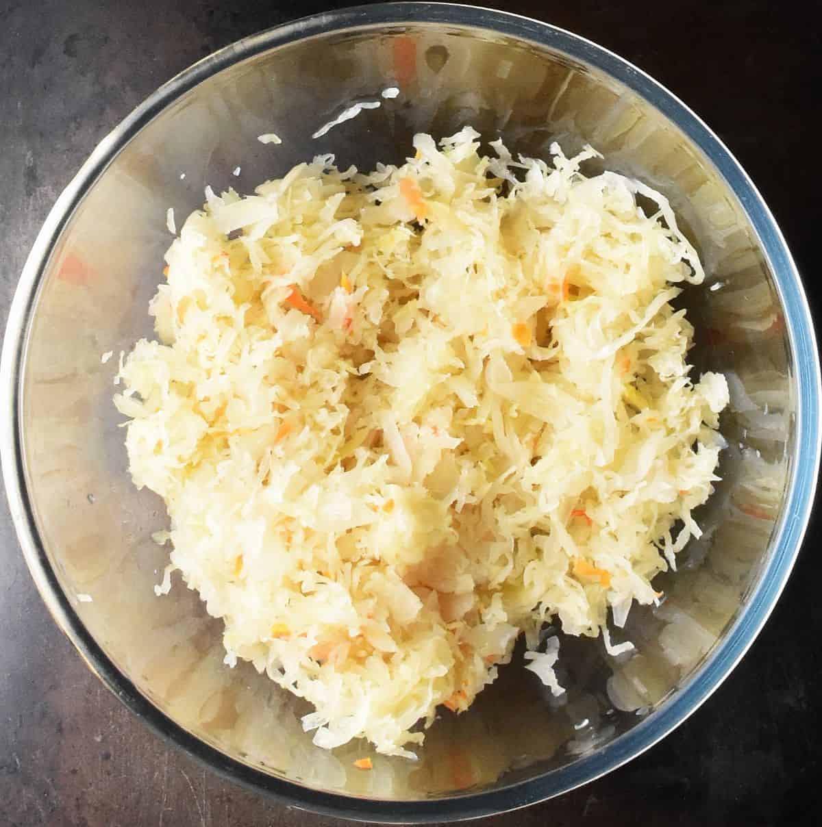 Chopped sauerkraut in large glass bowl.