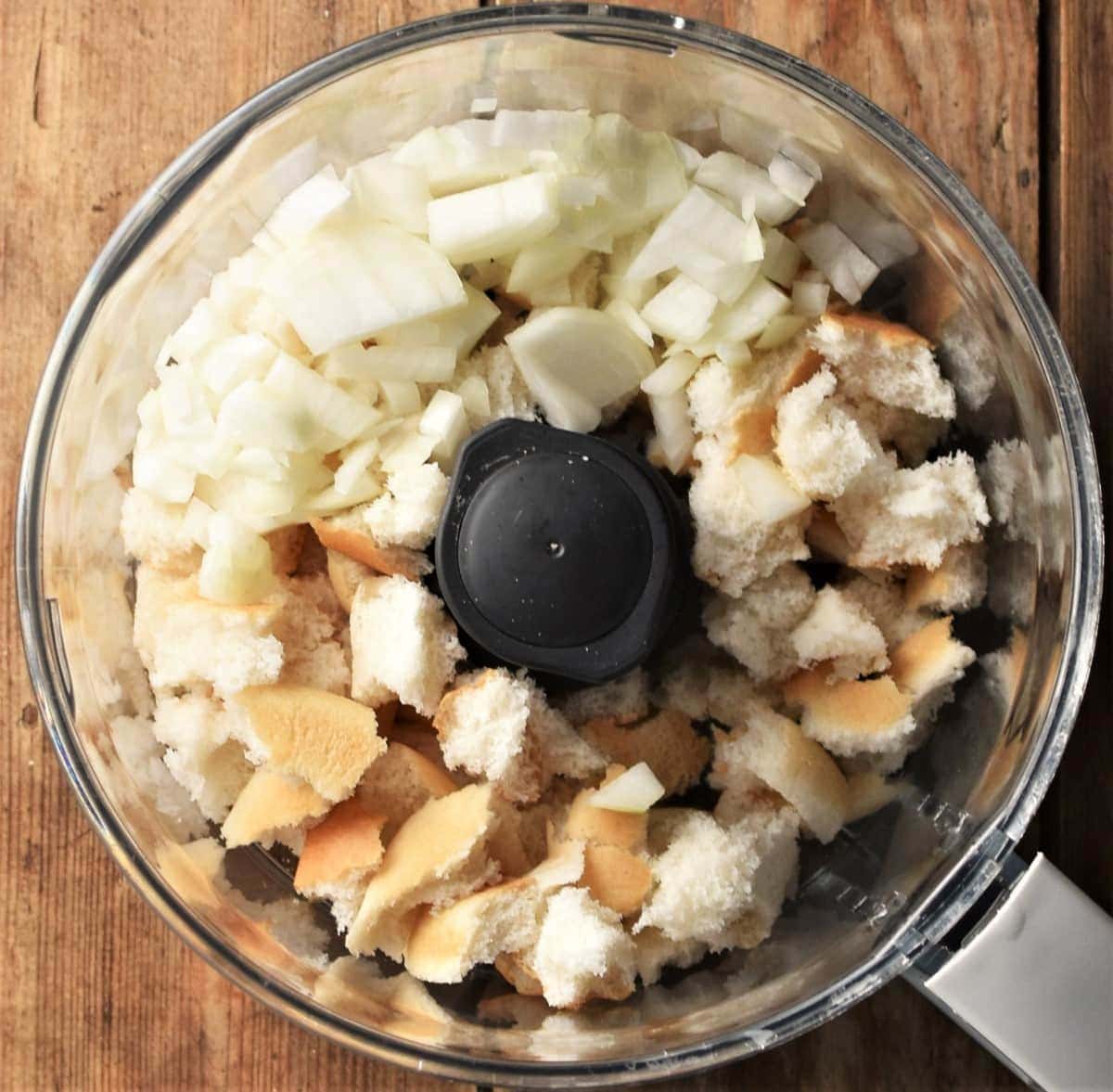 Pieces of bread and chopped onion in food processor bowl.