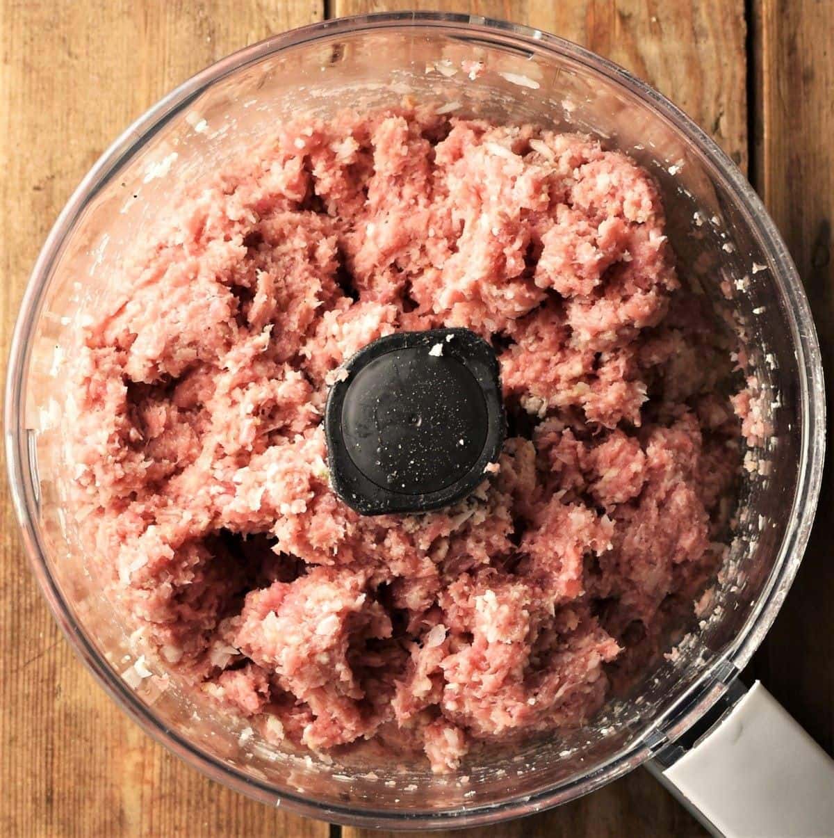 Meatball mixture inside food processor bowl.