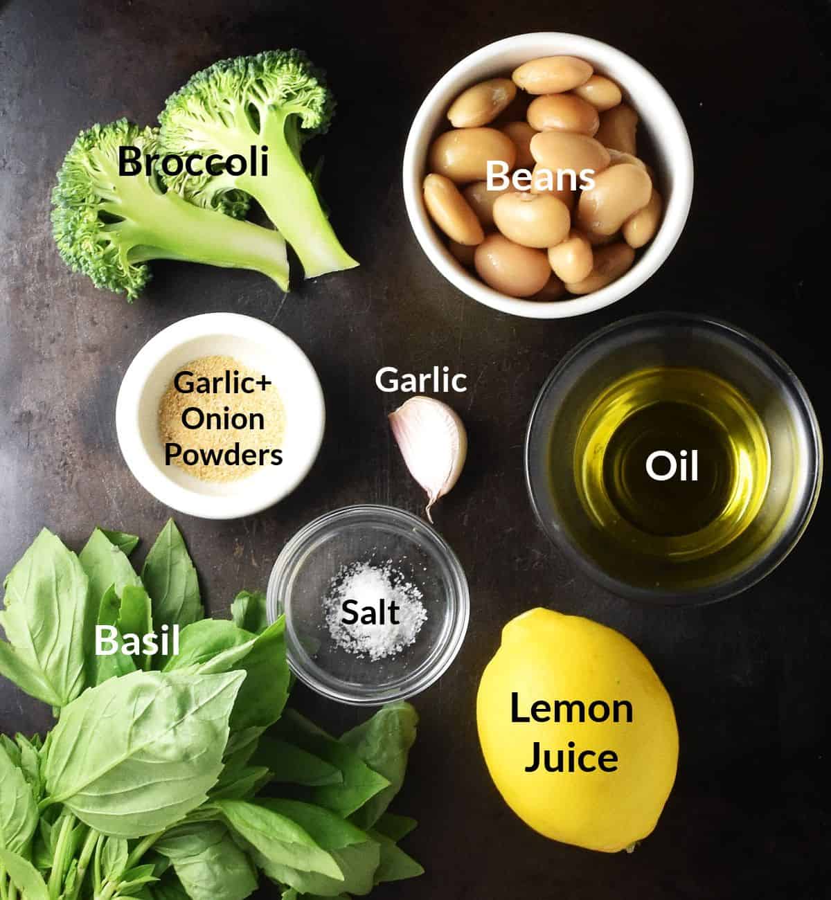 Top down view of broccoli dip ingredients in individual dishes on black surface.