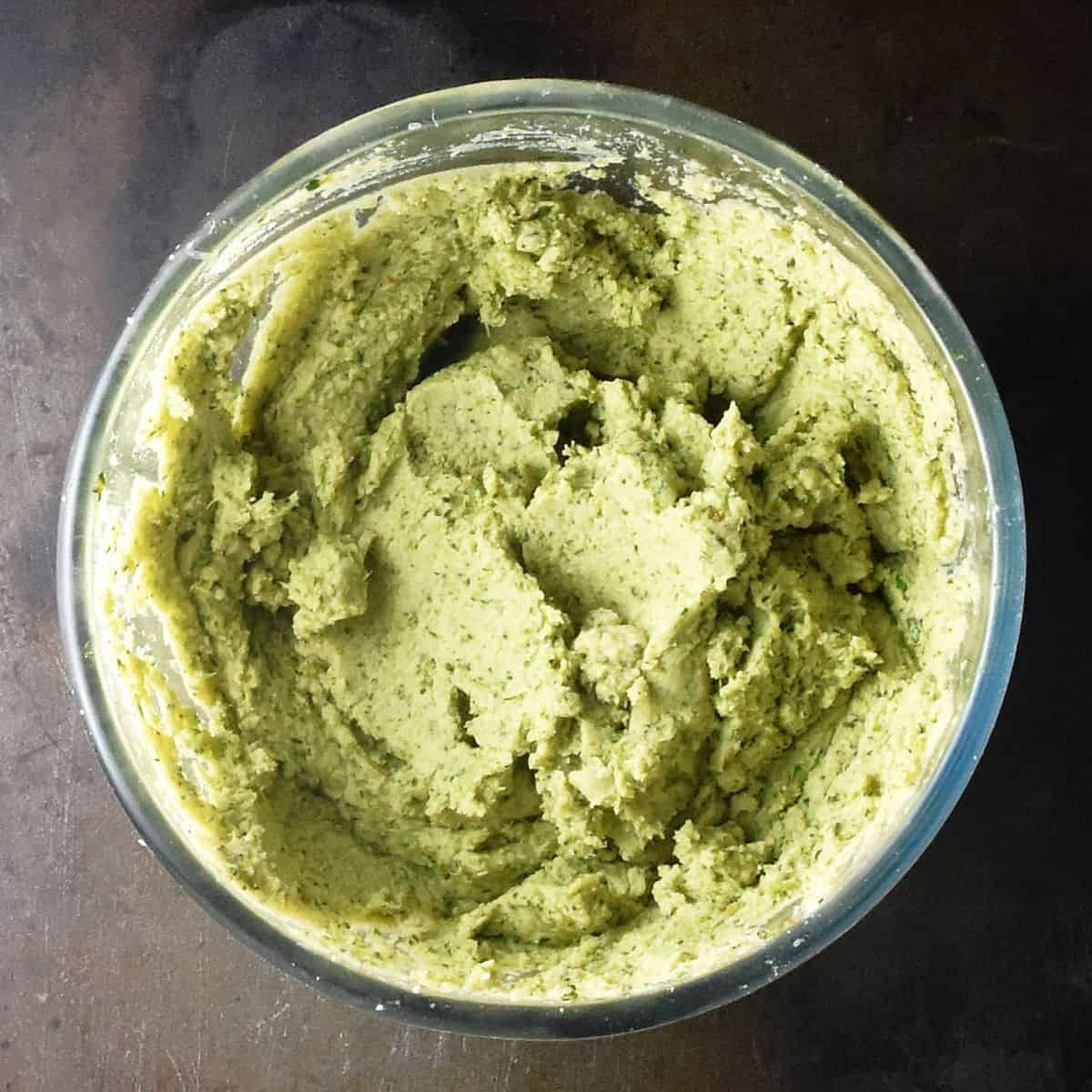 Top down view of creamy broccoli dip puree in glass bowl.