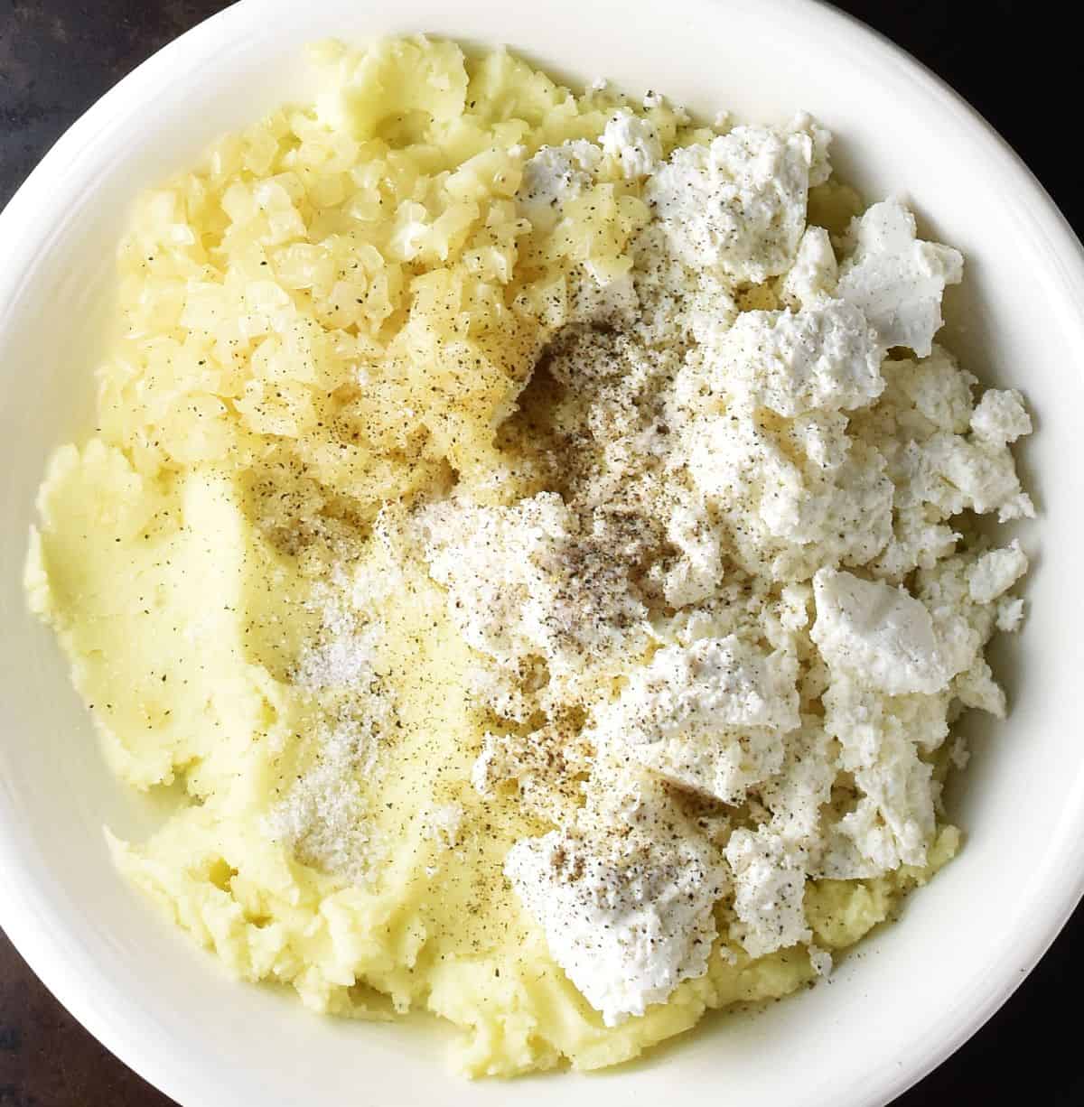 Top down view of mashed potato with Polish twarog cheese in white bowl.