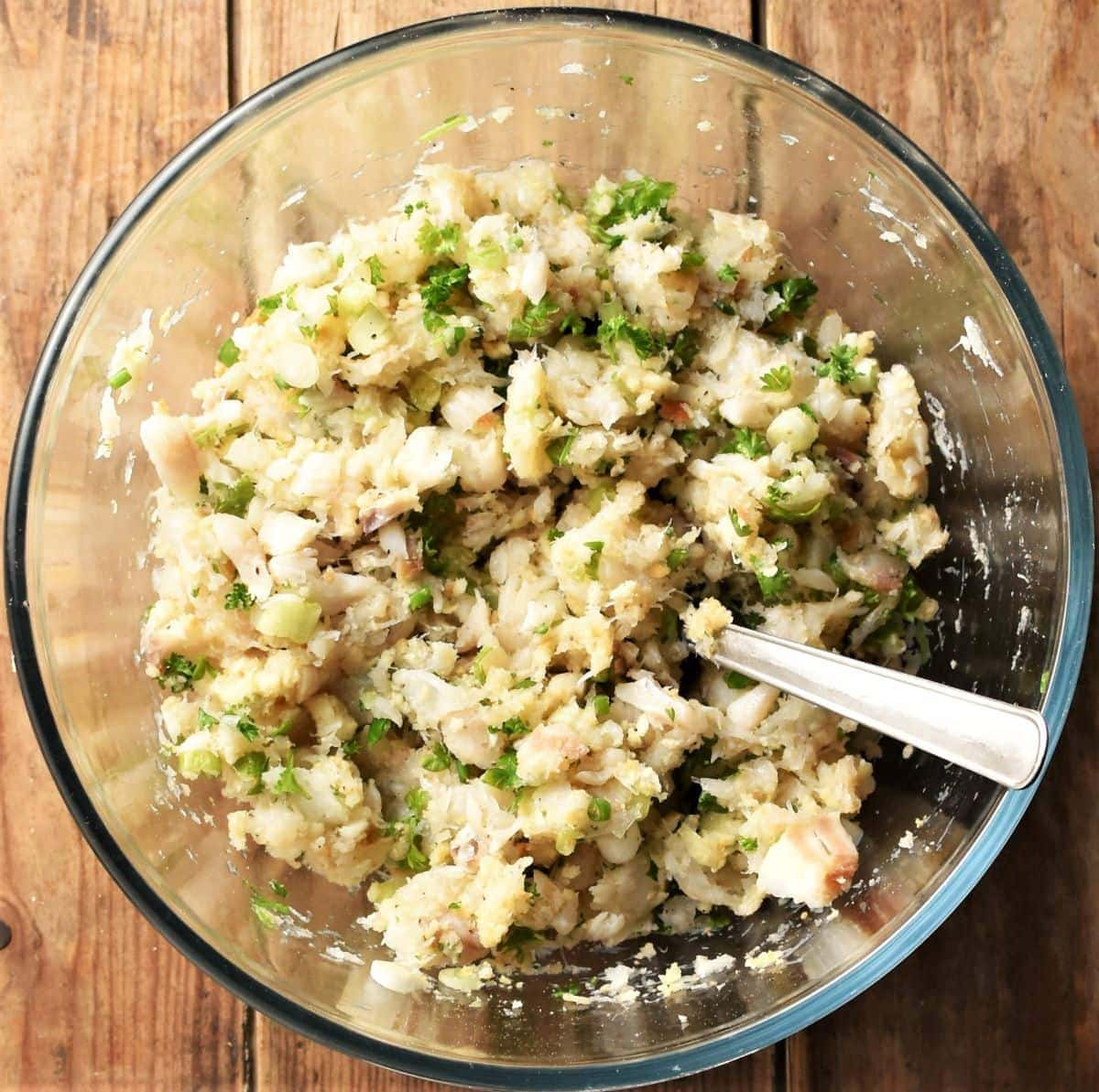 Fish cakes mixture in bowl with spoon.