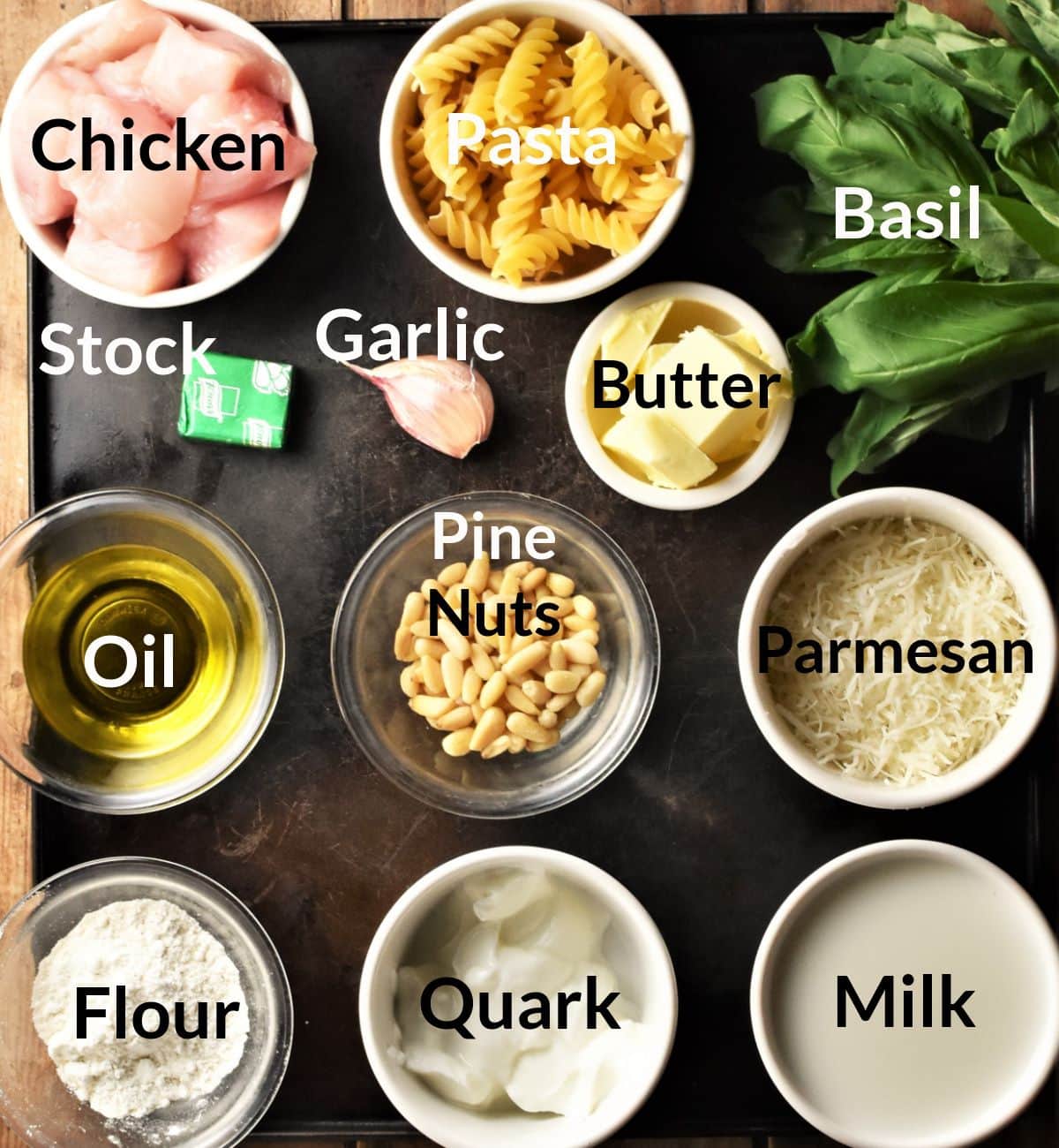 Ingredients for making creamy pesto pasta chicken bake in individual dishes.