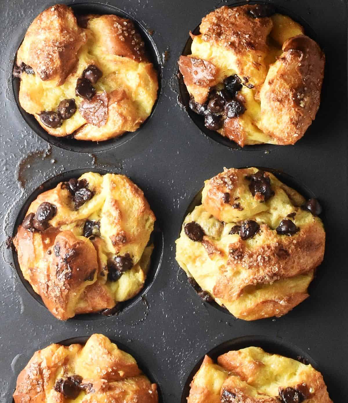Top down view of baked french toast muffins with chocolate chips in pan.