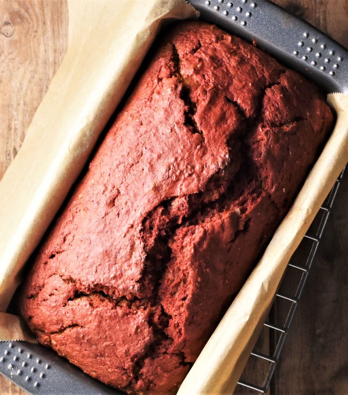 Baked beetroot bread in pan lined with parchment.