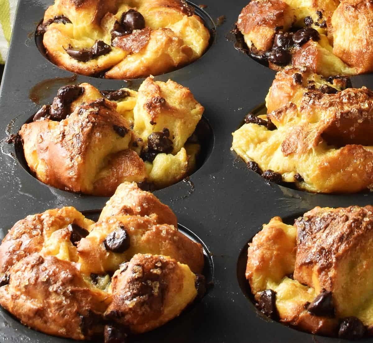 Side view of crispy, browned brioche muffin cups in pan.