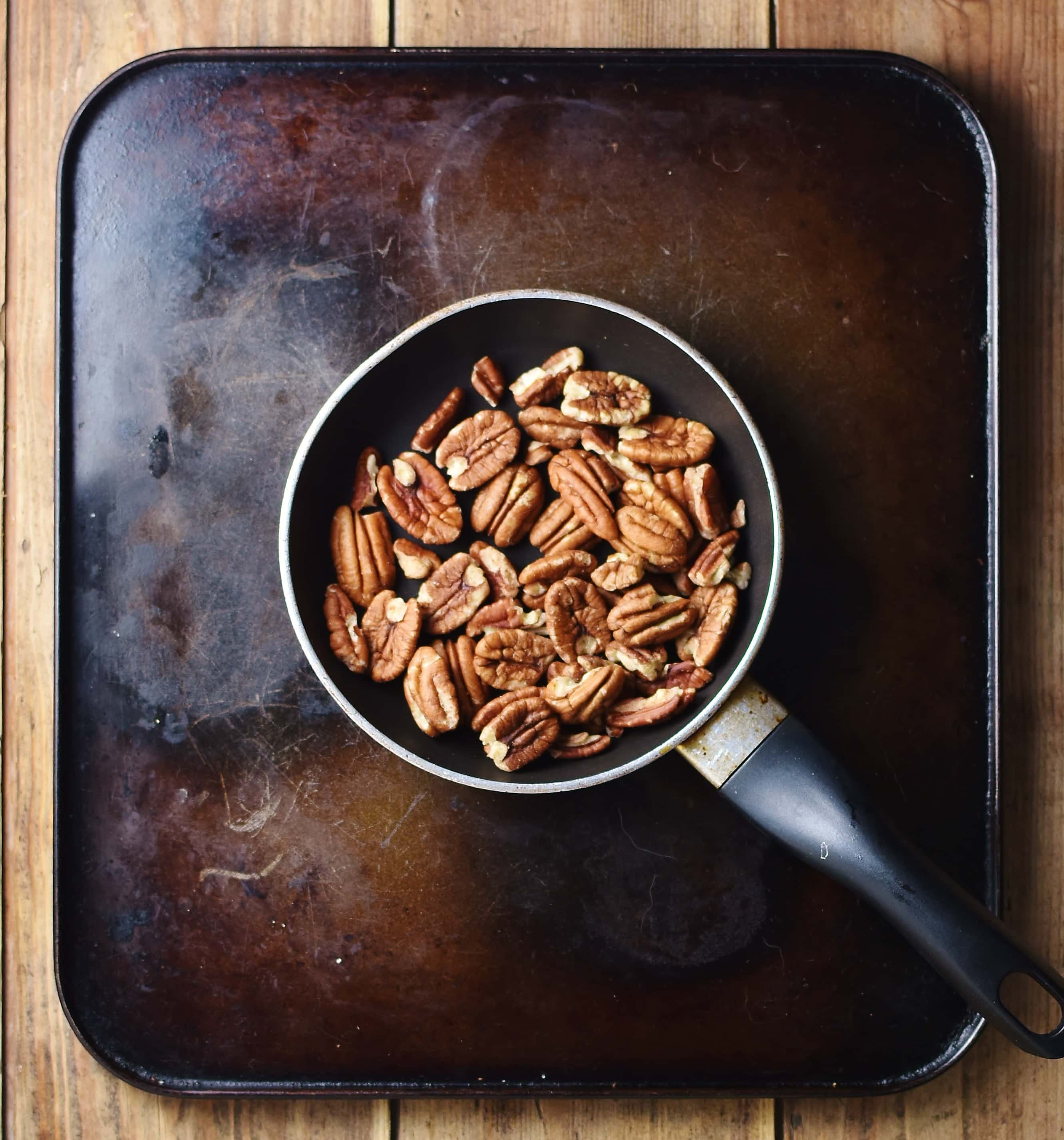 Top down view of pecans in small pan.
