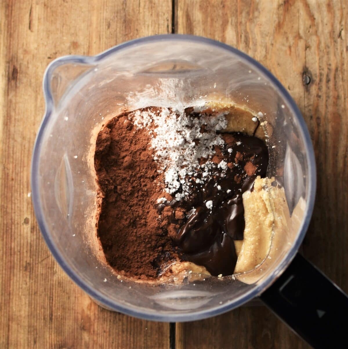 Cacao, nut butter, melted chocolate and powdered sugar in blender.