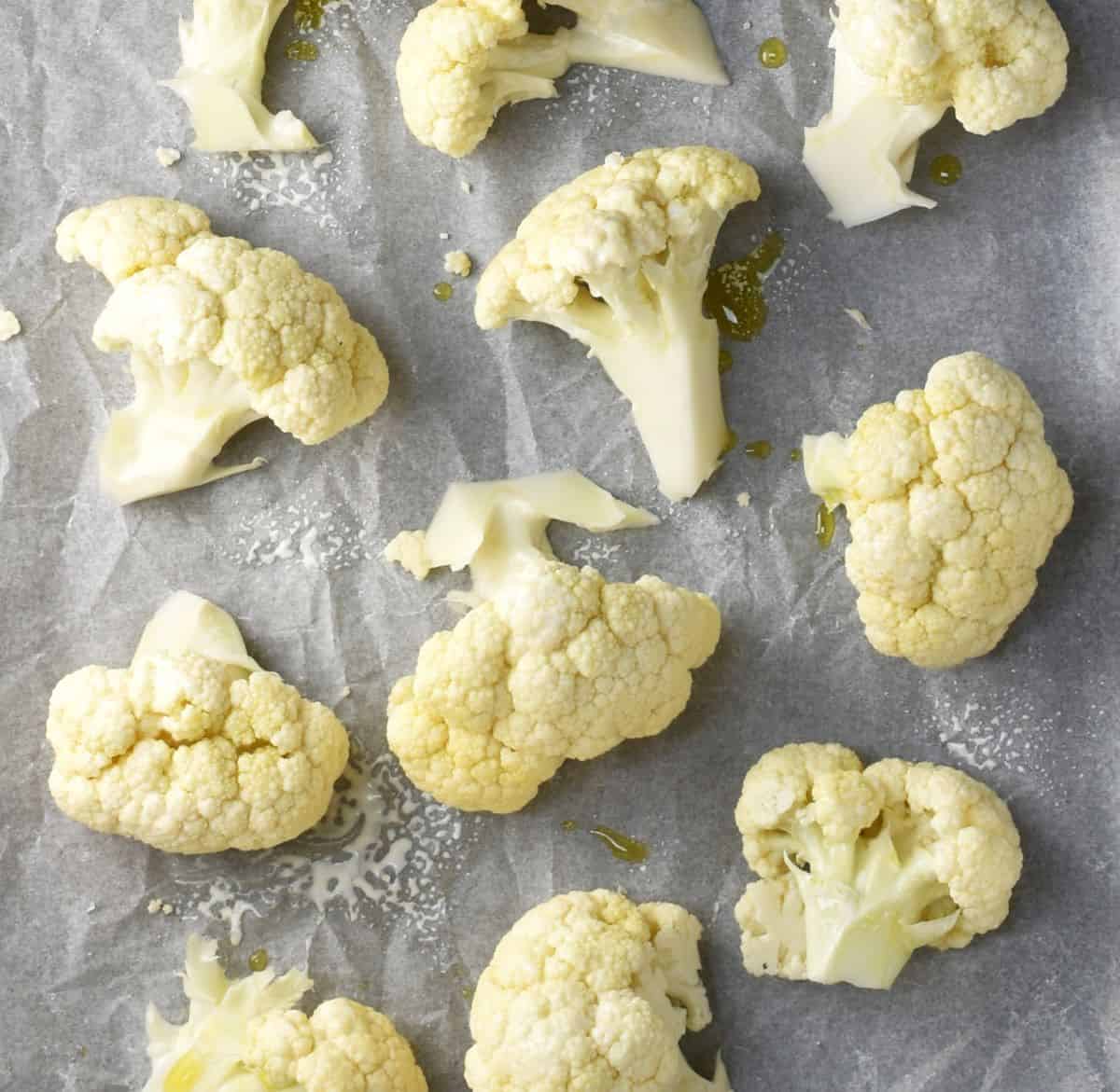 Top down view of cauliflower florets on parchment.