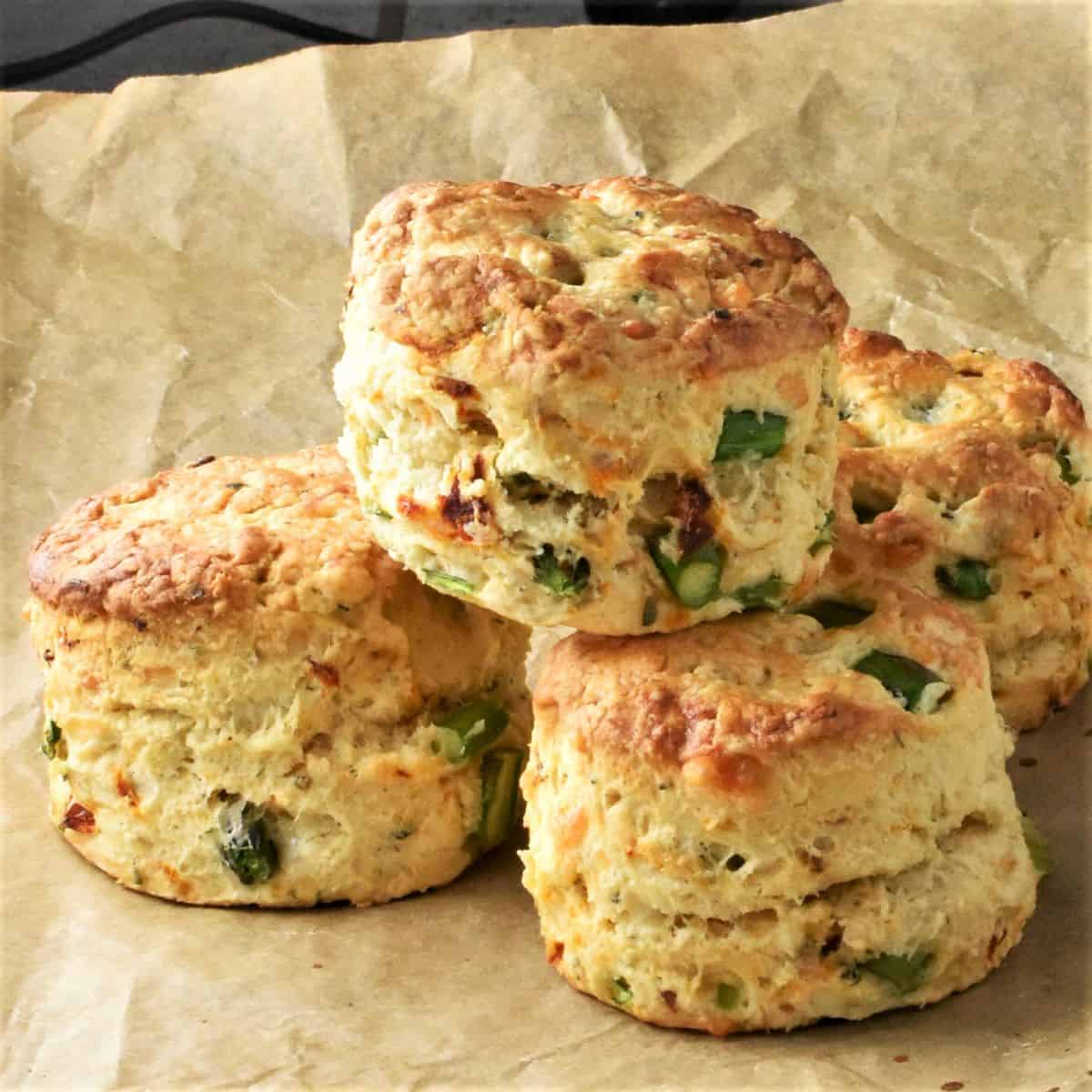 Side view of sun dried tomato scones on top of parchment.