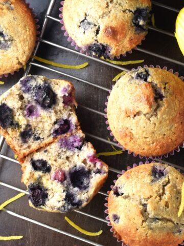 Top down view of blueberry buckwheat muffins with lemon on rack.