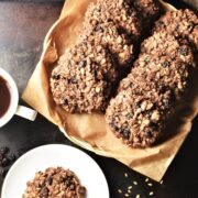 Top down view of chocolate oatmeal cookies on top of parchment and small plate.