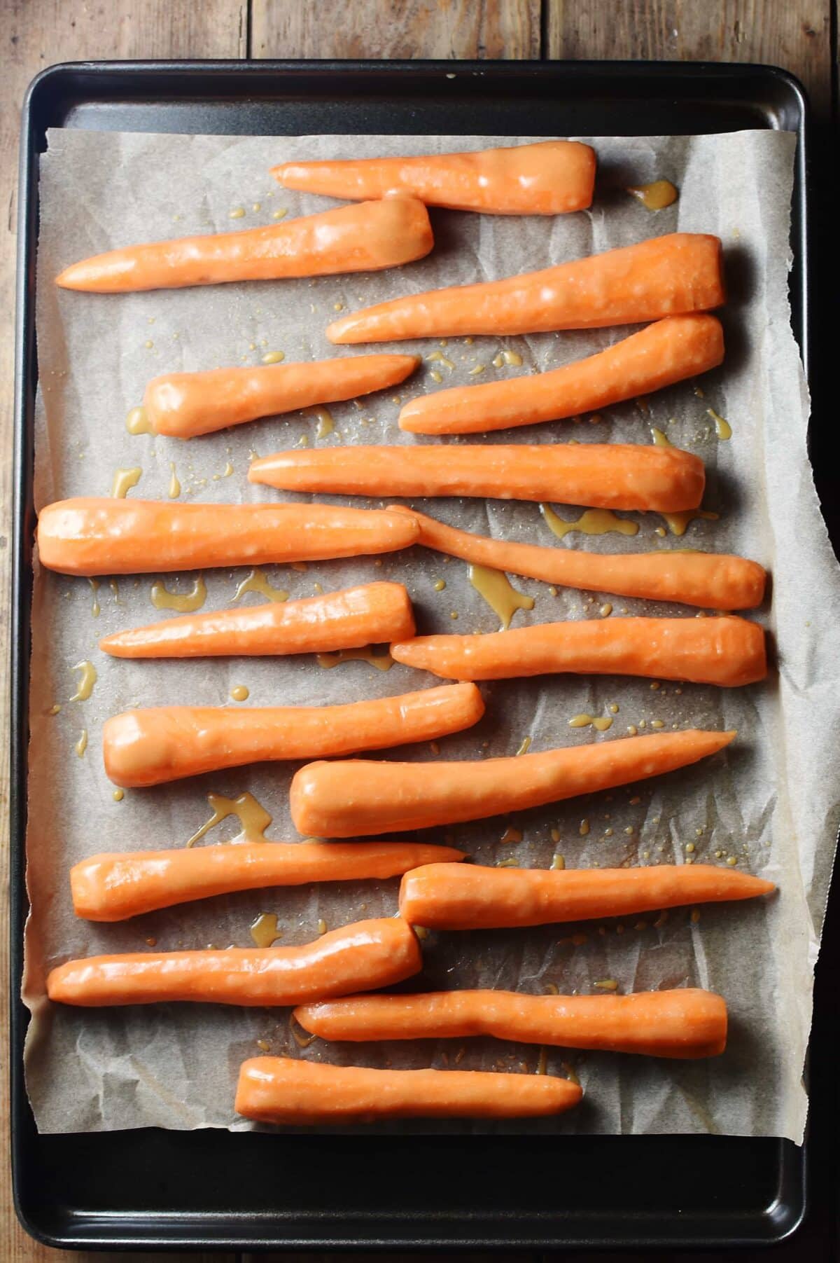 Honey glazed carrots on top of baking paper. 